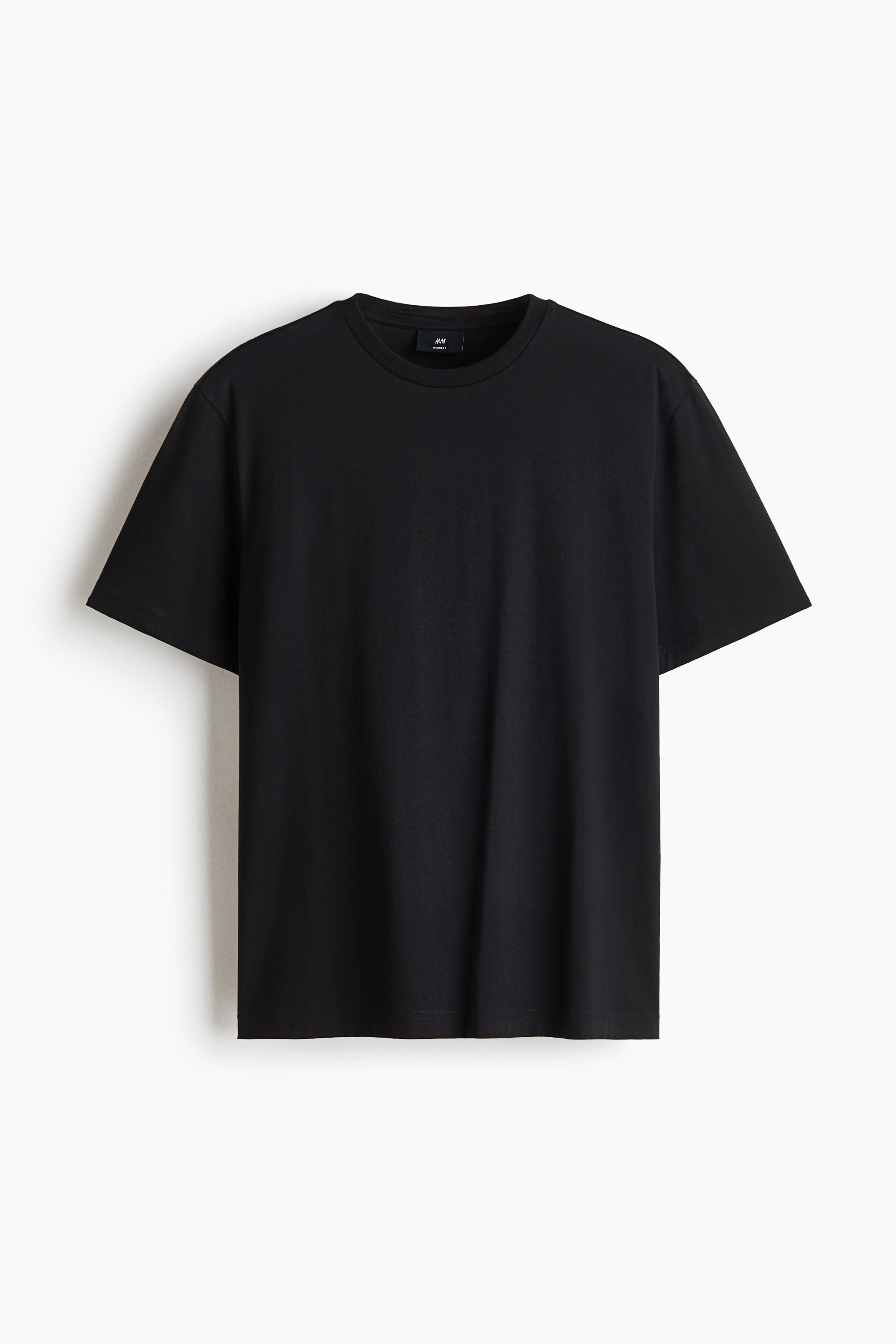 Ein schwarzes T-Shirt ist von vorne zu sehen und verfÃ¼gt Ã¼ber einen klassischen gerippten Rundhalsausschnitt, kurze Ãrmel und einen geraden Saum. Das KleidungsstÃ¼ck zeigt ein glattes, einfarbiges Gewebe mit einer Regular-Fit-Silhouette.