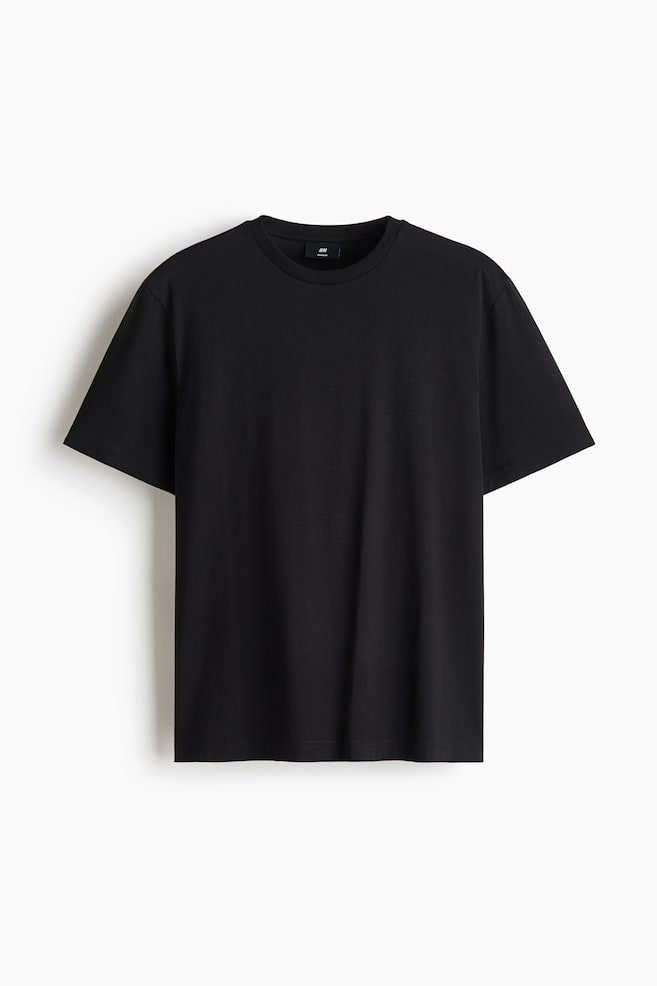 Czarny T-shirt jest ukazany od przodu i ma klasyczny prÄ
żkowany okrÄ
gÅy dekolt, krótkie rÄkawy oraz prosty dóÅ. Ubranie prezentuje gÅadkÄ
, jednokolorowÄ
tkaninÄ i regularny fason. - 1