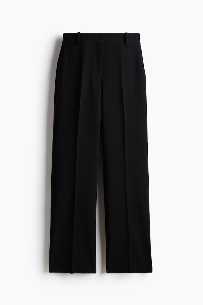 Black tailored trousers in woven fabric are being presented from the front, featuring a high waist, a concealed zip fly with button and hook-and-bar fasteners, and diagonal side pockets. The straight legs are displaying prominent creases down the front. - 1