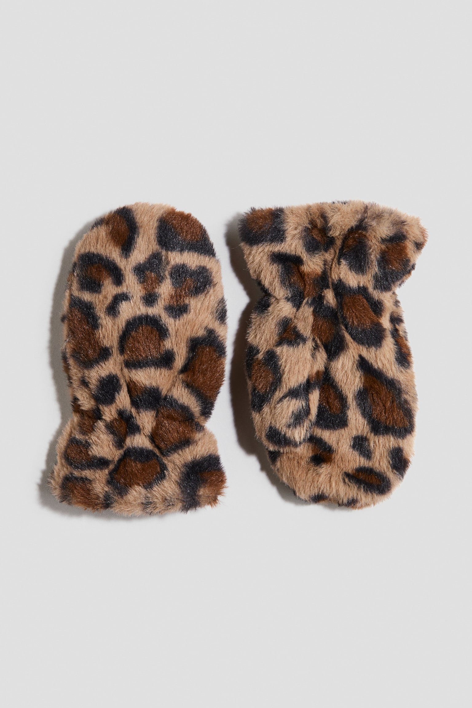 Par rukavica od veÅ¡taÄkog krzna sa leopard printom leÅ¾i ravno, prikazujuÄi pliÅ¡anu teksturu sa crnim, braon i svetlosmeÄim peÄatima. Rukavica levo pokazuje zaobljenu zadnju stranu, dok rukavica desno otkriva unutraÅ¡nju stranu dlana sa odeljkom za palac i skupljenim, elastiÄnim ruÄnim zglobom.