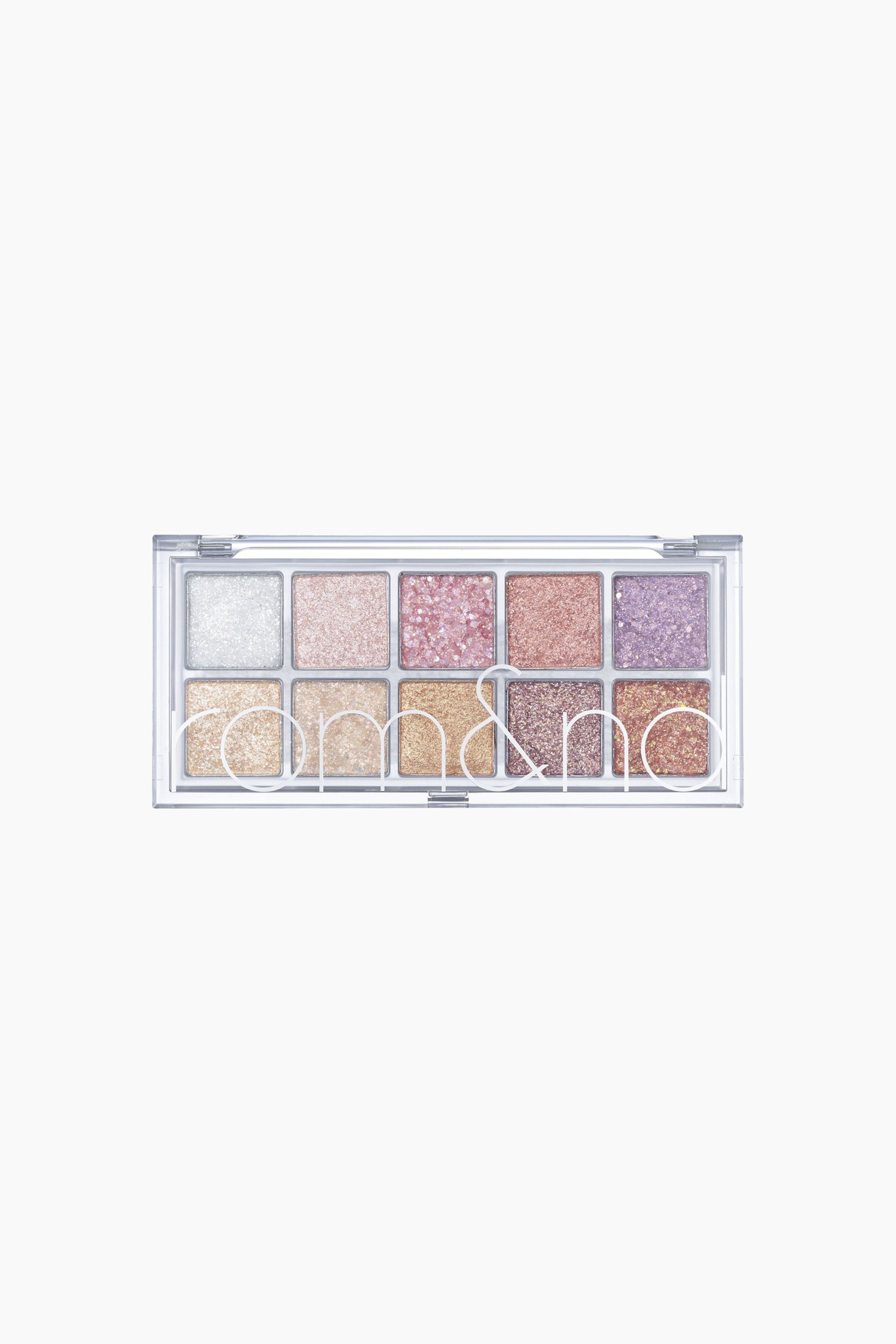 Visa större bild: En transparent plastögonskuggspalett visar 10 fyrkantiga skuggor med glitterögonskugga, arrangerade i två rader om fem. Översta raden innehåller nyanser i silver, rosa och lavendel, medan nedersta raden visar olika guld- och bronsnyanser, med varumärket "rom&nd" tydligt präglat över de nedersta fem skuggorna.
