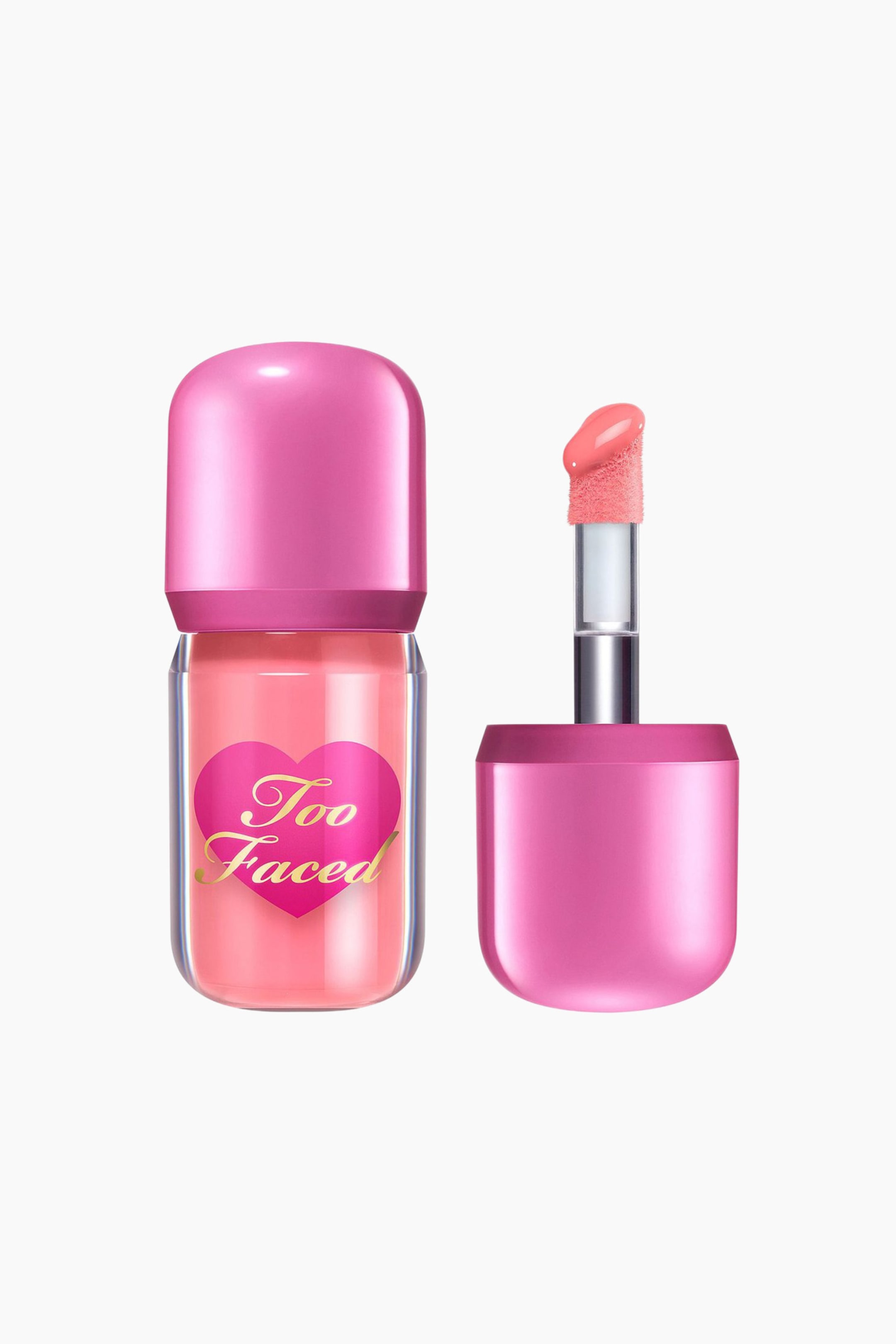 Visa större bild: En läppglans med en genomskinlig plastbehållare fylld med persikorosa glans, visar en het rosa hjärtetikett med "Too Faced" i guld, och en matchande rundad het rosa kork. Den avtagna applikatorn, med sitt matchande heta rosa handtag, visar en luddig doe-foot spets täckt i samma persikorosa glans, som sträcker sig från en silver- och genomskinlig stav.