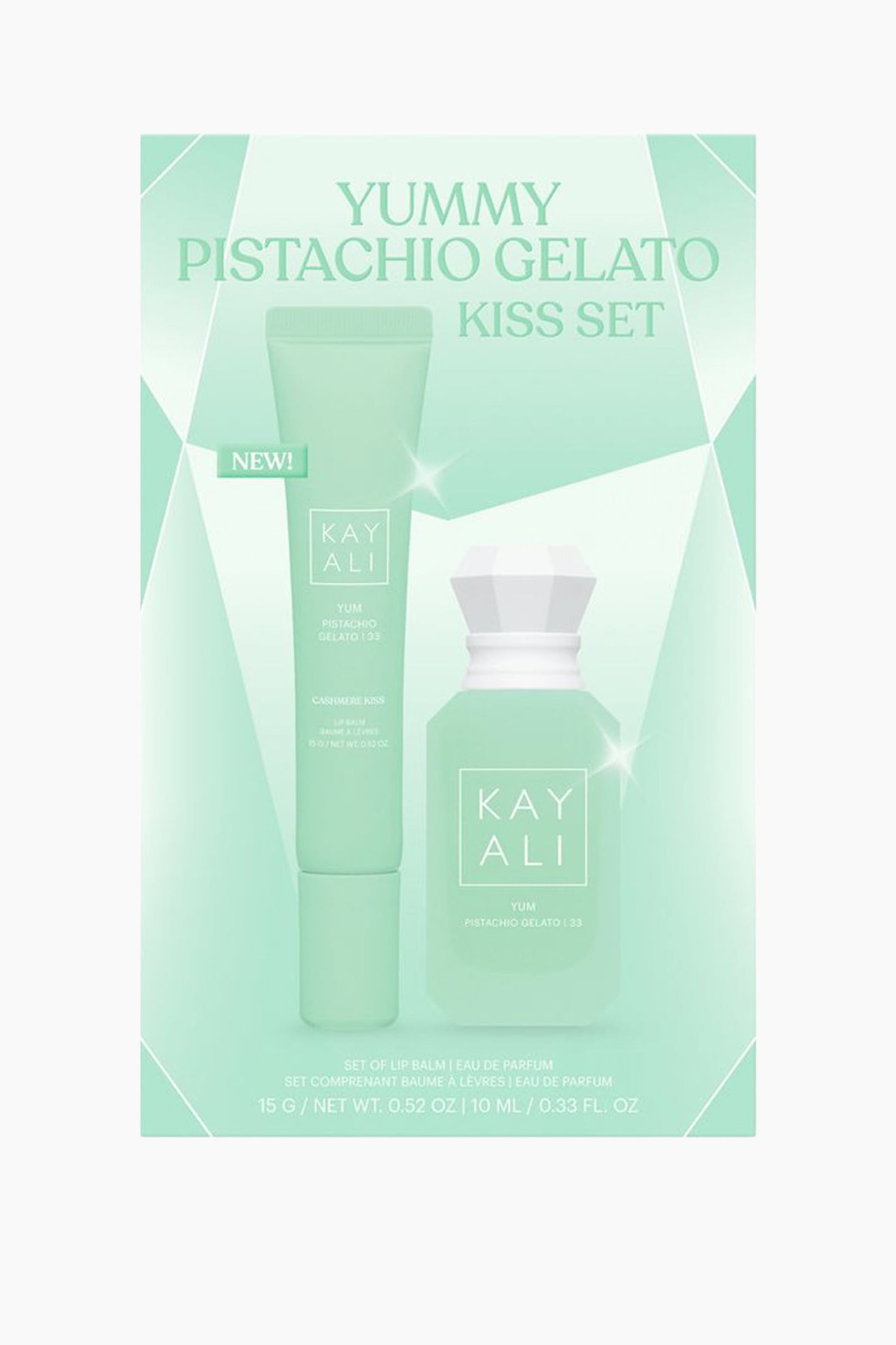 Näytä suurempi kuva: Mintunvihreä pakkauslaatikko esittelee Kayali Yummy Pistachio Gelato Kiss Set -lahjasetin, jossa vasemmalla on puristettava huulivoideputki ja oikealla pienikokoinen kahdeksankulmainen hajuvesipullo, jossa on valkoinen fasetoitu korkki. Molemmat tuotteet ovat eteenpäin suunnattuna, ja niissä näkyvät tuotemerkin nimi ja tuotetiedot valkoisella tekstillä.