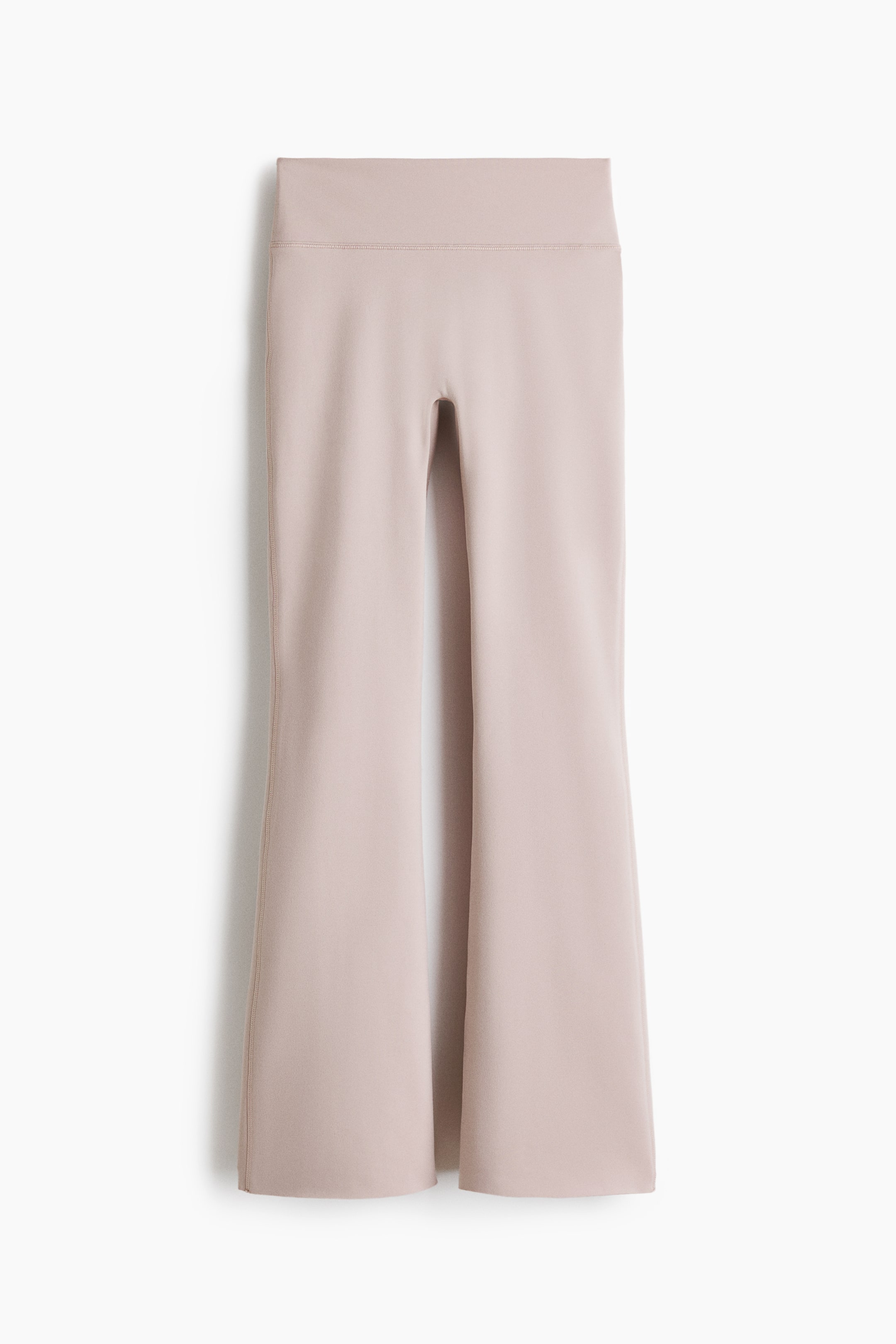 Ingrandisci l'immagine: I pantaloni sono di un colore beige chiaro e presentano una fascia in vita ampia e alta. Sono caratterizzati da un design a gamba svasata con una cucitura verticale prominente che corre lungo il centro anteriore di ciascuna gamba.