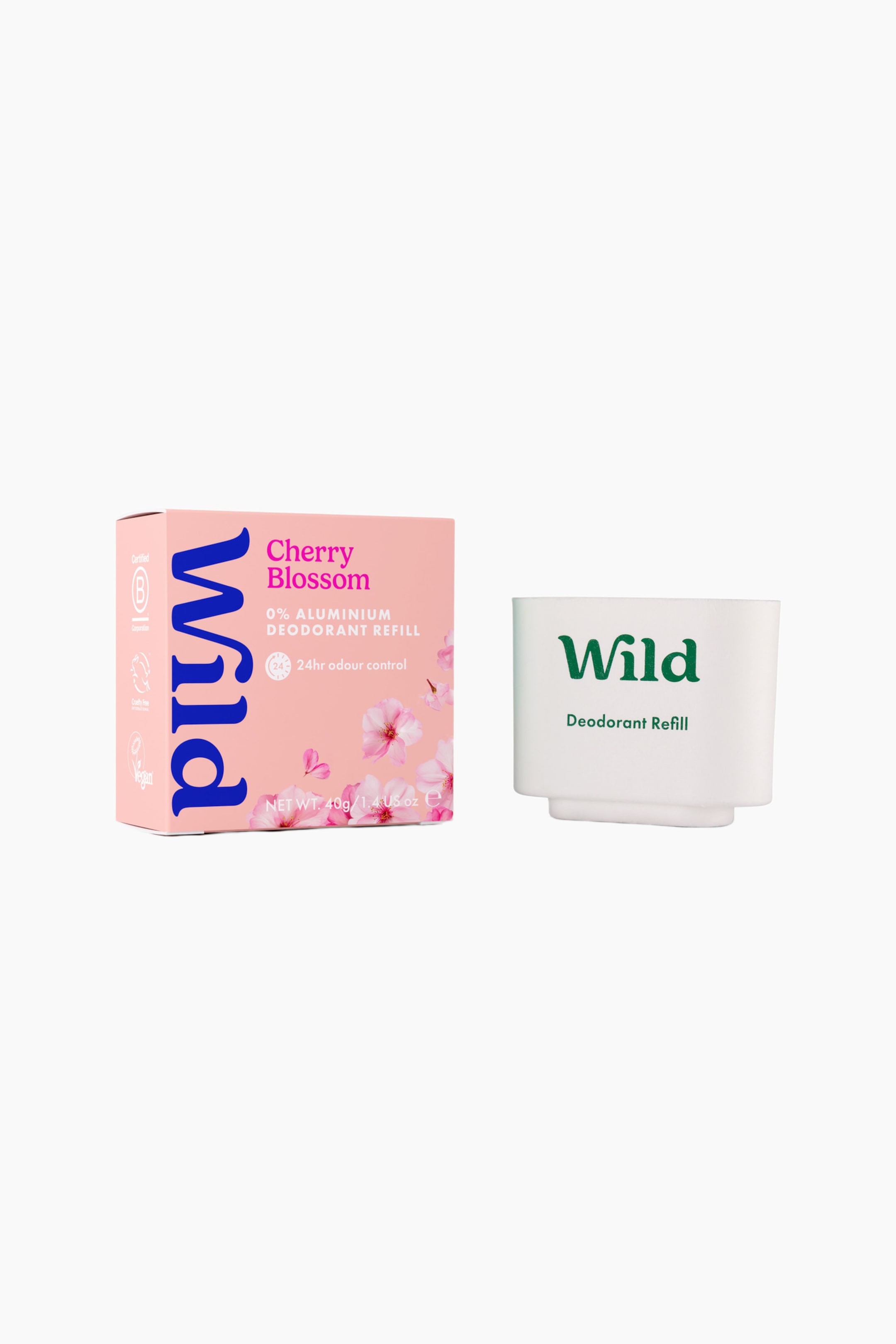 Visa större bild: En refill till deodorantstick står upprätt bredvid sin rosa förpackningsask i kartong. Den vita, formgjutna refilldelen visar den gröna ”Wild”-logotypen på framsidan, medan den rosa asken visar körsbärsblomsillustrationer och blå ”Wild”-branding.