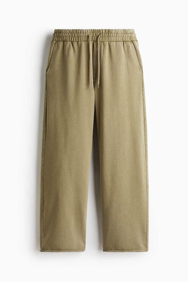 FRONT, these khaki sweatpants, made from heavyweight cotton sweatshirt fabric with a washed look, are displaying a relaxed fit. They are featuring a covered elasticated waist with a drawstring, a mock fly seam, and two side pockets. - 1