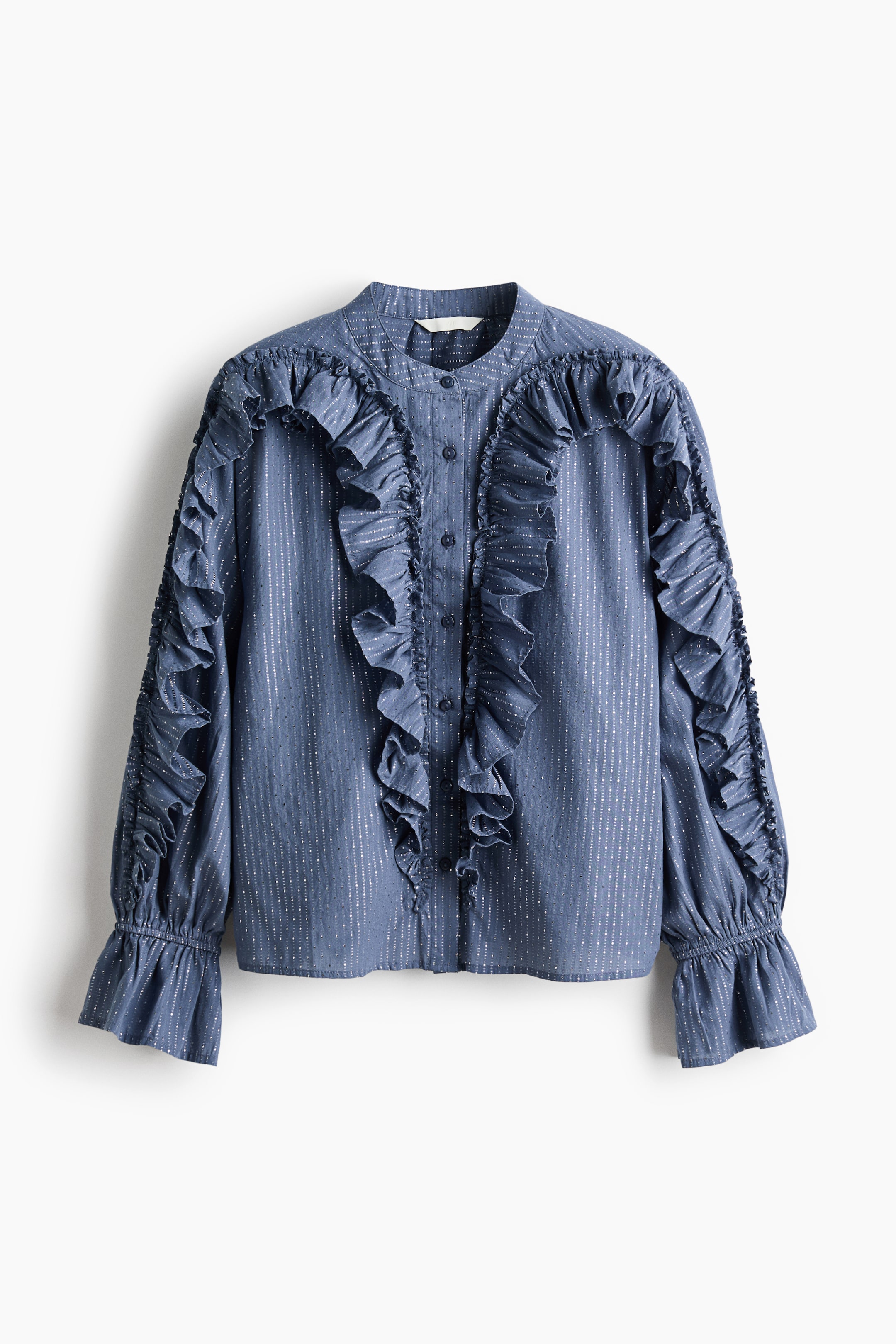 Agrandir l'image: Une blouse bleue est présentée à l'AVANT, avec des rayures verticales scintillantes, un col mao, une patte de boutonnage sur le devant, et des volants proéminents courant le long du devant, sur les épaules, et le long des manches longues, qui se terminent par des poignets froncés à volants.