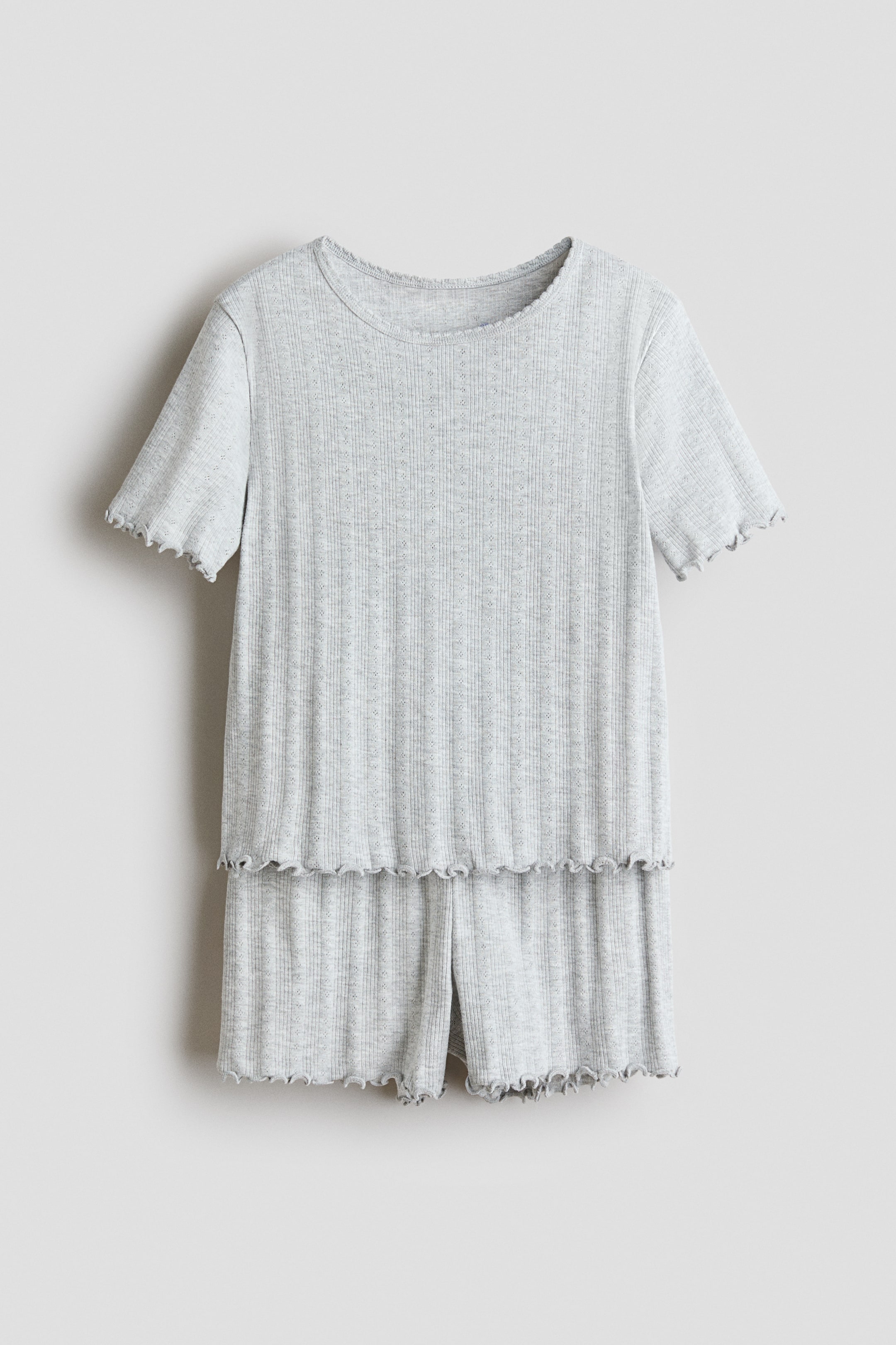 View larger image: Pyjamas in light grey ribbed cotton jersey showcase a short-sleeved top with a round neckline and overlocked edges at the cuffs and hem, along with matching shorts featuring overlocked hems.