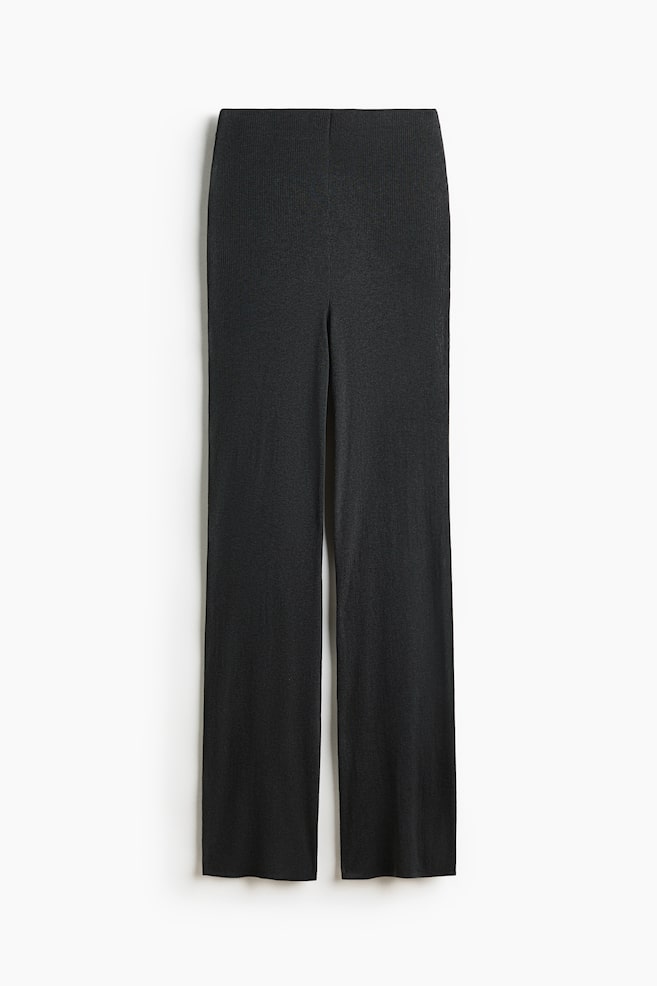 Black fitted trousers are shown flat, front-facing. They feature a distinct rib-knit texture, a smooth waistband, and straight legs. - 1
