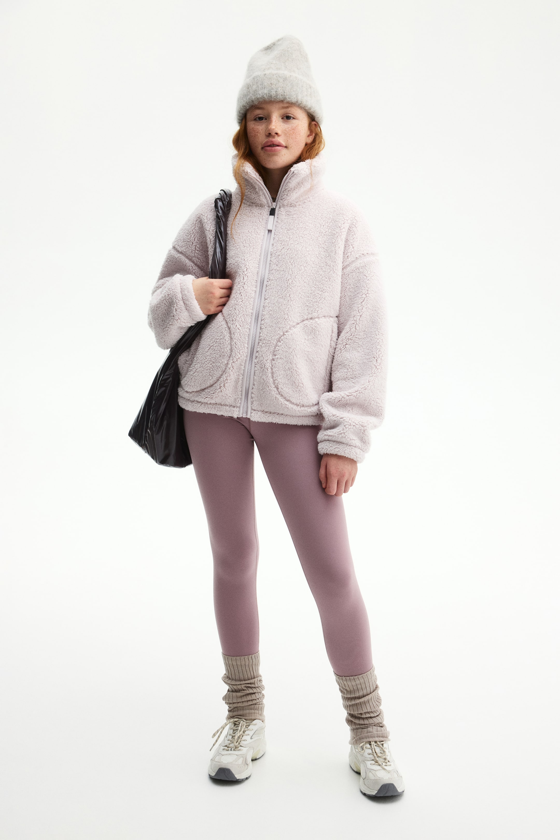 Prikaži veću sliku: Ljubičasta teddy fleece jakna opuštenog kroja prikazana je u potpunom prednjem prikazu. Prikazuje se sa rajsferšlusom svetle boje, visokim okovratnikom i dva velika, zaobljena džepa sa prednje strane.