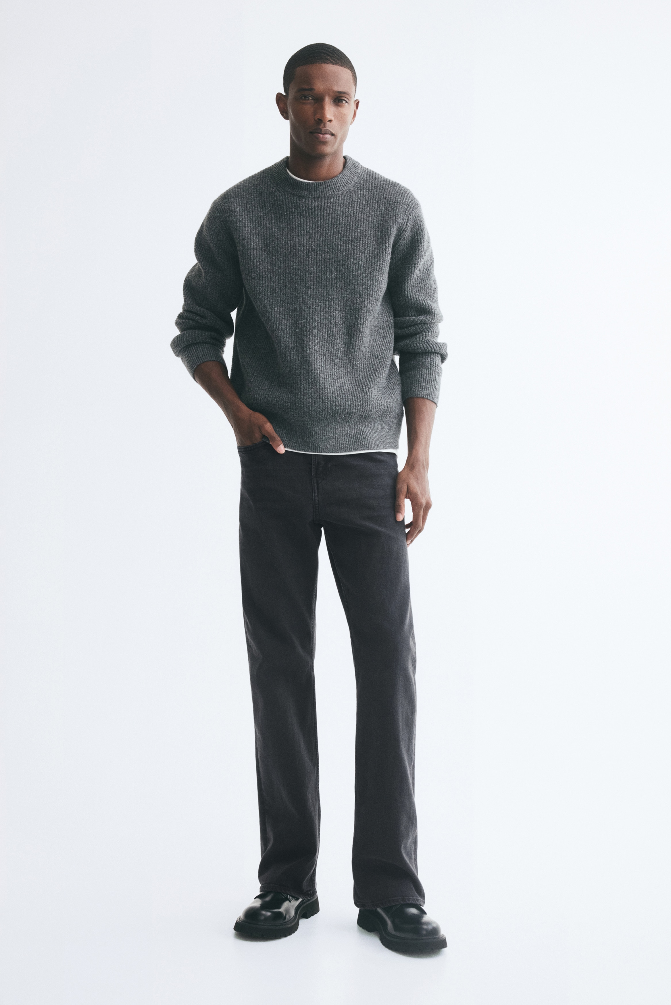 O pereche de blugi negri decoloraÈi este prezentatÄ din faÈÄ, evidenÈiind un design clasic cu cinci buzunare, Ã®nchidere cu nasture Èi gÄici pentru curea Ã®n talie. Blugii au o croialÄ slim pe coapsÄ, care se evazeazÄ uÈor la tiv.