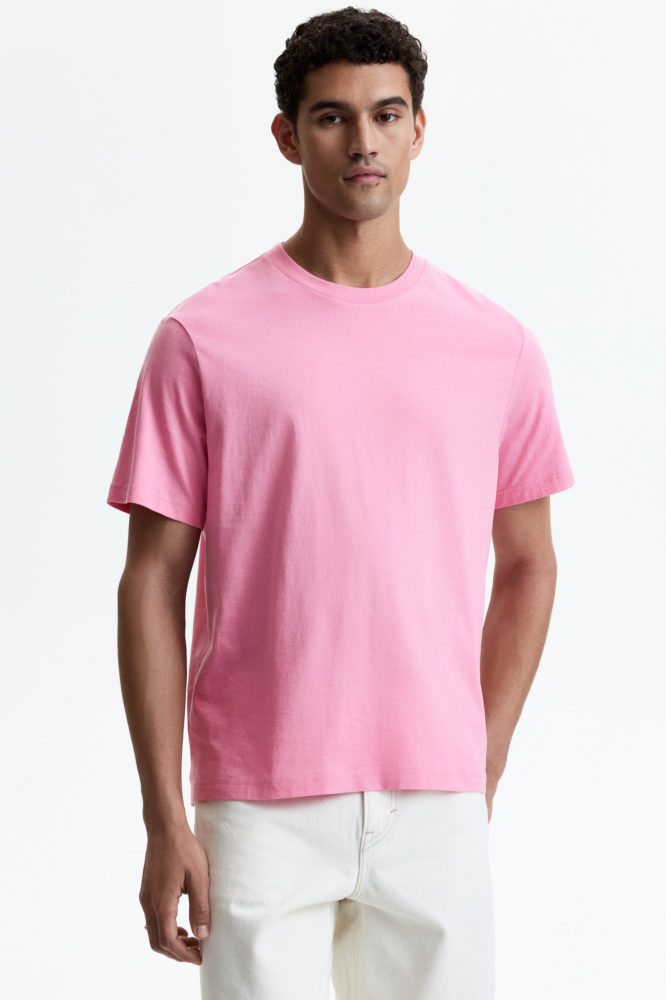View larger image: This pink t-shirt showcases a crew neck, short sleeves, and a straight hemline. It offers a relaxed fit and is displayed from a front-facing perspective.