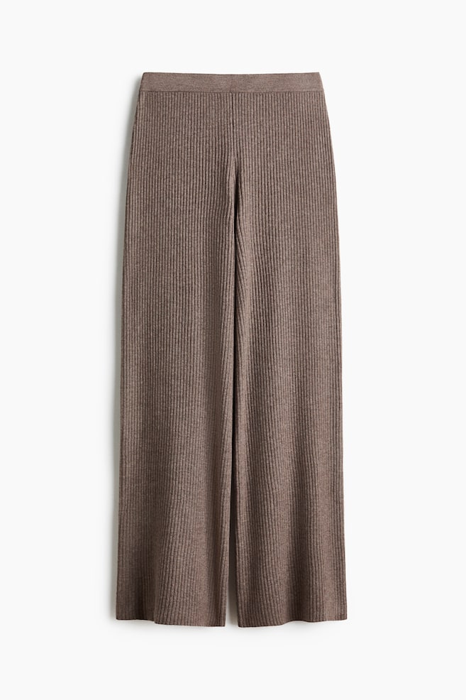 Brown ribbed knit trousers are lying flat, presenting a front-on view. They feature a wide-leg design and a flat knit waistband. - 1