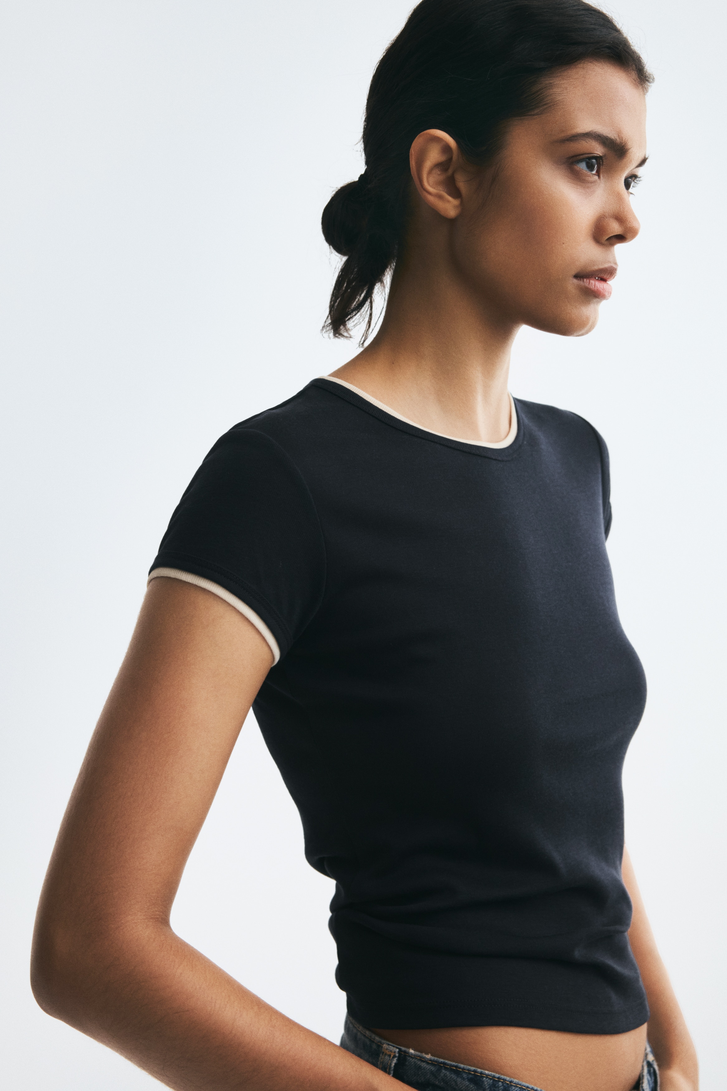 This dark navy short-sleeved T-shirt is shown from the front, featuring a crew neckline and sleeve cuffs with contrasting cream-coloured ringer trim.