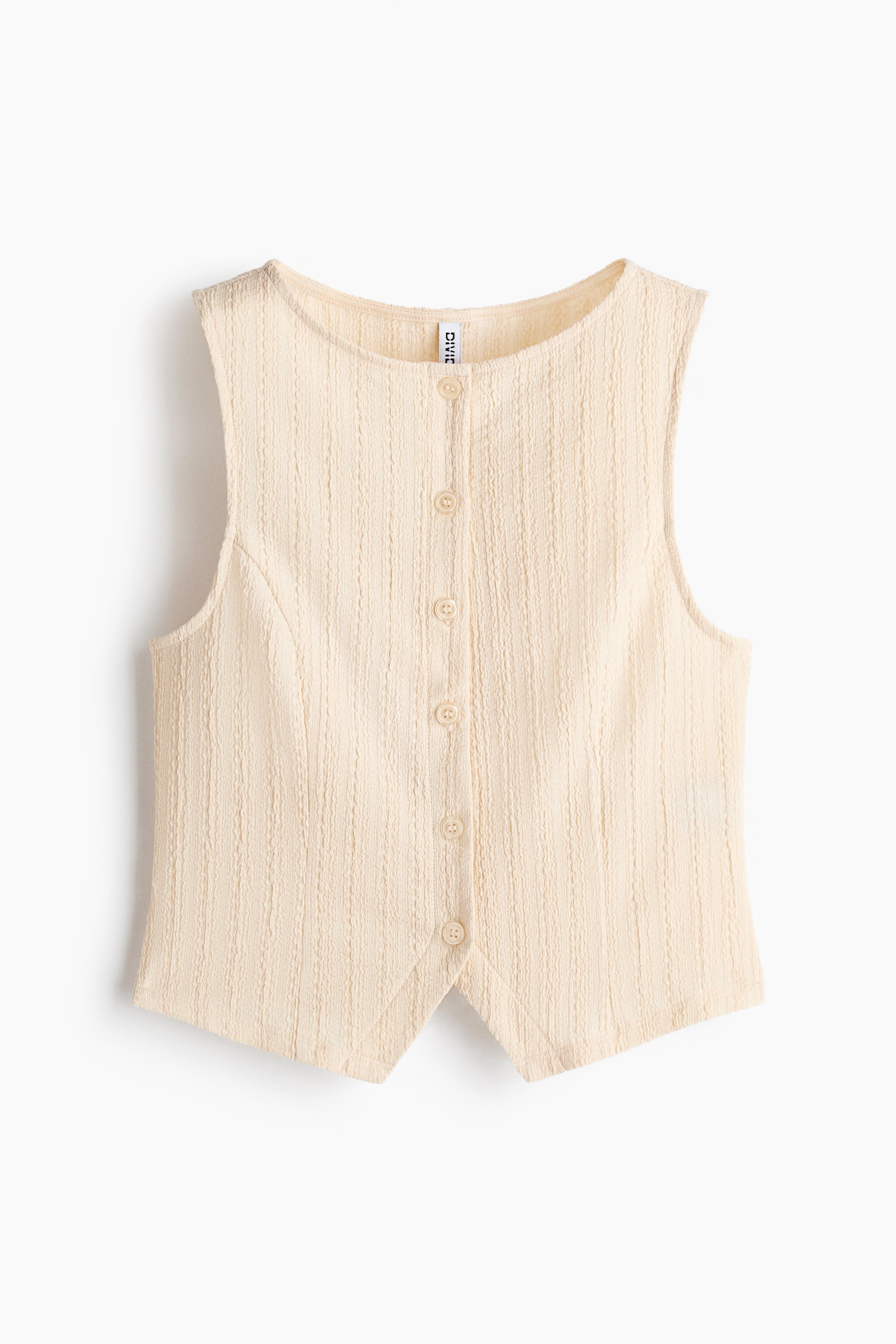 View larger image: A cream-colored sleeveless vest is presenting its FRONT, featuring a textured fabric with vertical raised lines, a round neckline, and a full button-front closure that is showcasing six matching circular buttons. Its front hem is forming a pointed shape.
