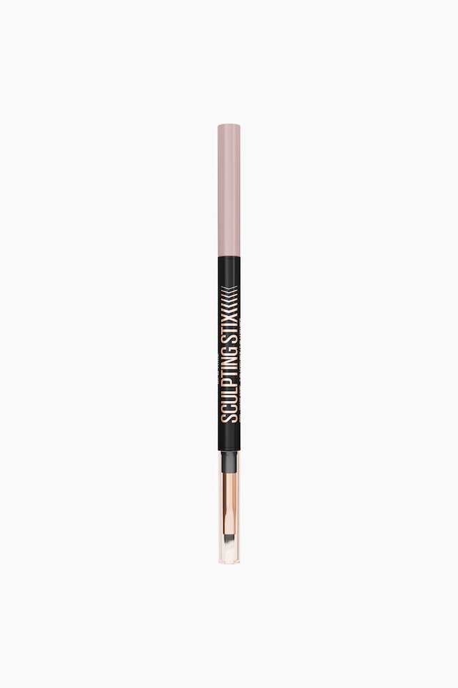 En kosmetikstift med to ender står lodret og vender fremad. Den har en lyserød cylindrisk top, et sort midterstykke med "SCULPTING STIX" i guldskrift og chevron-mønstre, samt en gennemsigtig hætte i bunden, der afslører en børsteapplikator med en lys spids og et skaft i rosaguld. - 1