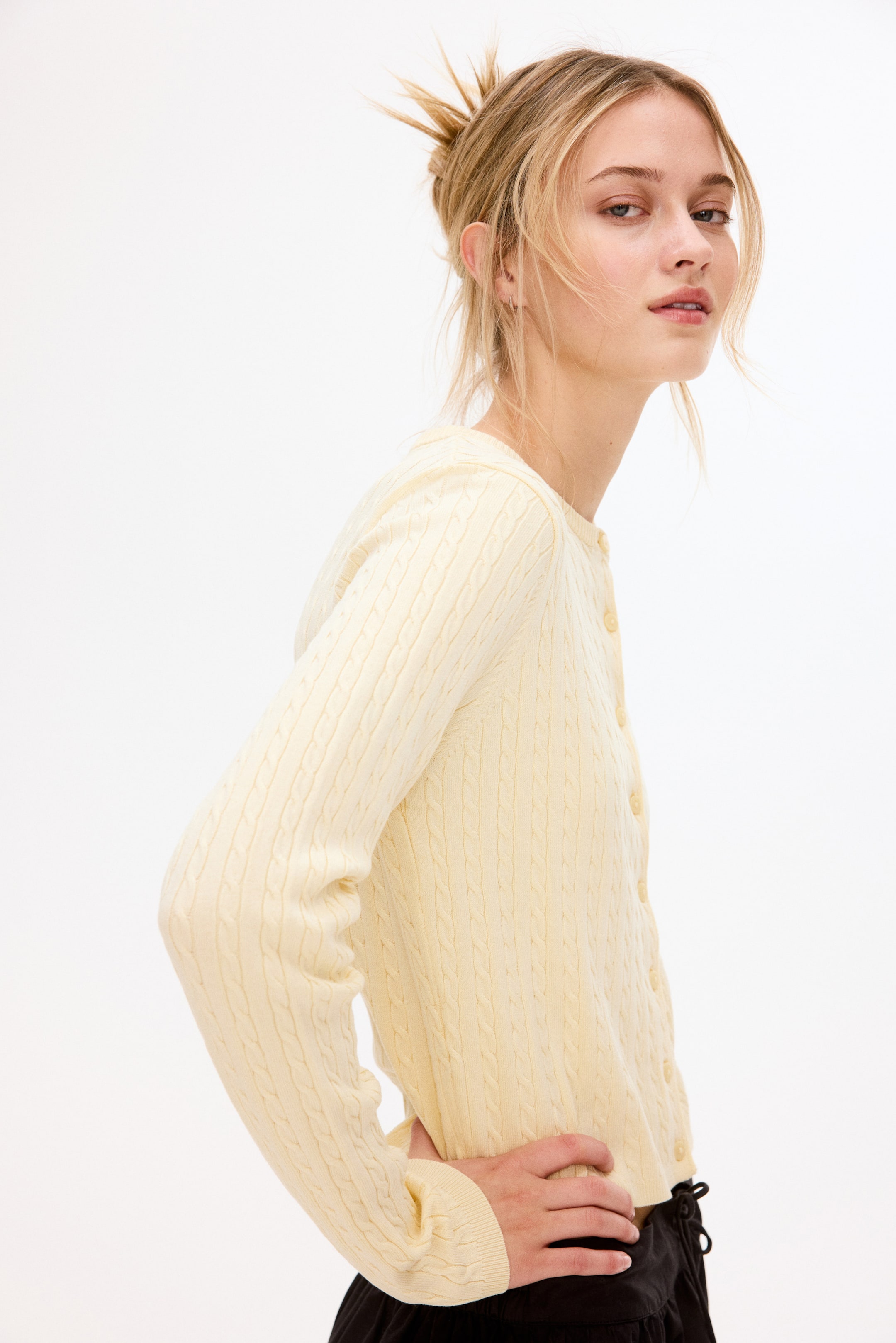 Prikaži veću sliku: Lagani žuti kardigan sa pletenim uzorkom prikazuje svoj bočni pogled, sa teksturiranim pletenim uzorkom, dugim rukavima sa rebrastim manžetnama i dugmadima u boji duž prednje strane.