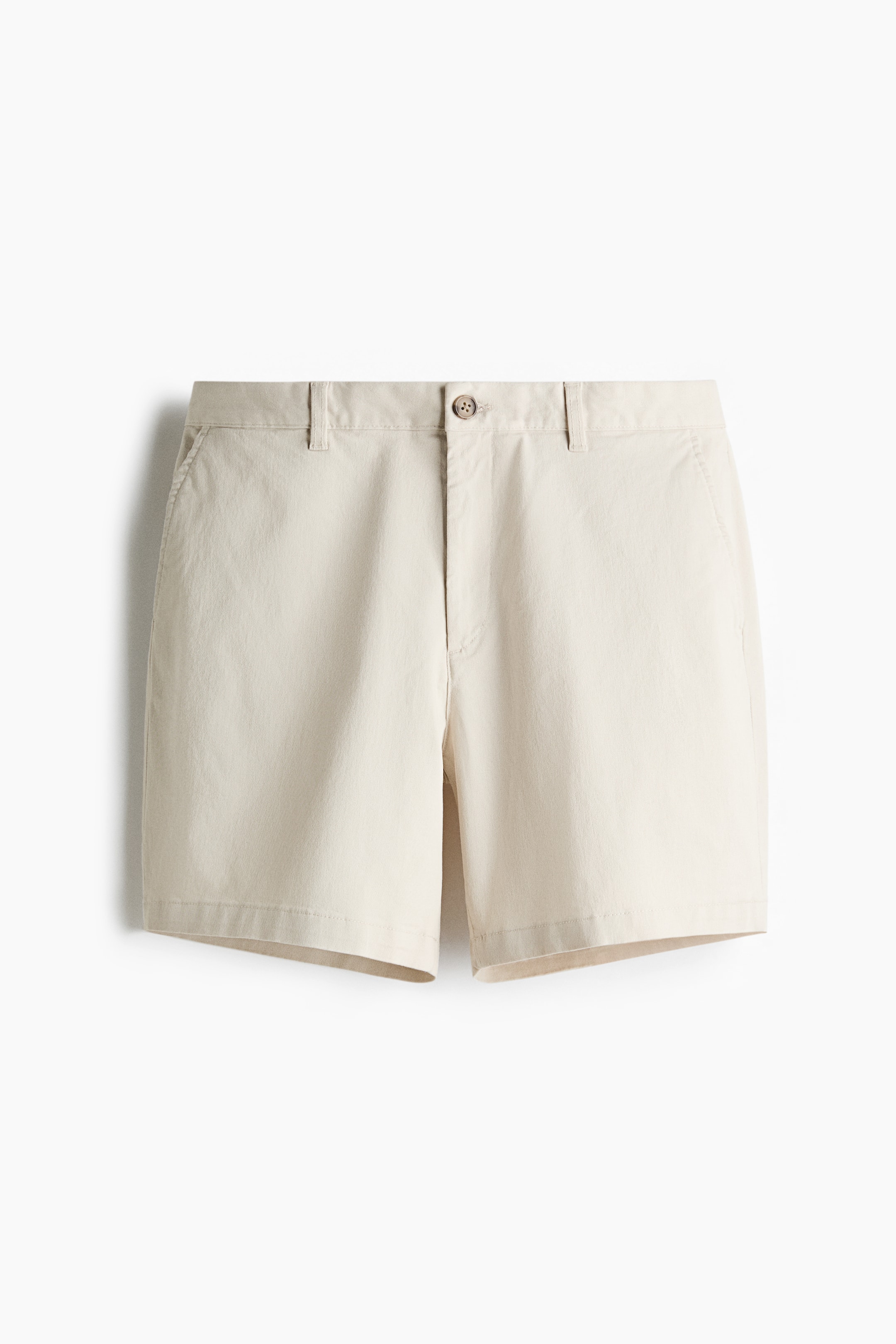 View larger image: Light beige shorts shown from the front, featuring a button closure at the waistband, belt loops, angled side pockets, and a straight cut with hems that fall above the knee.