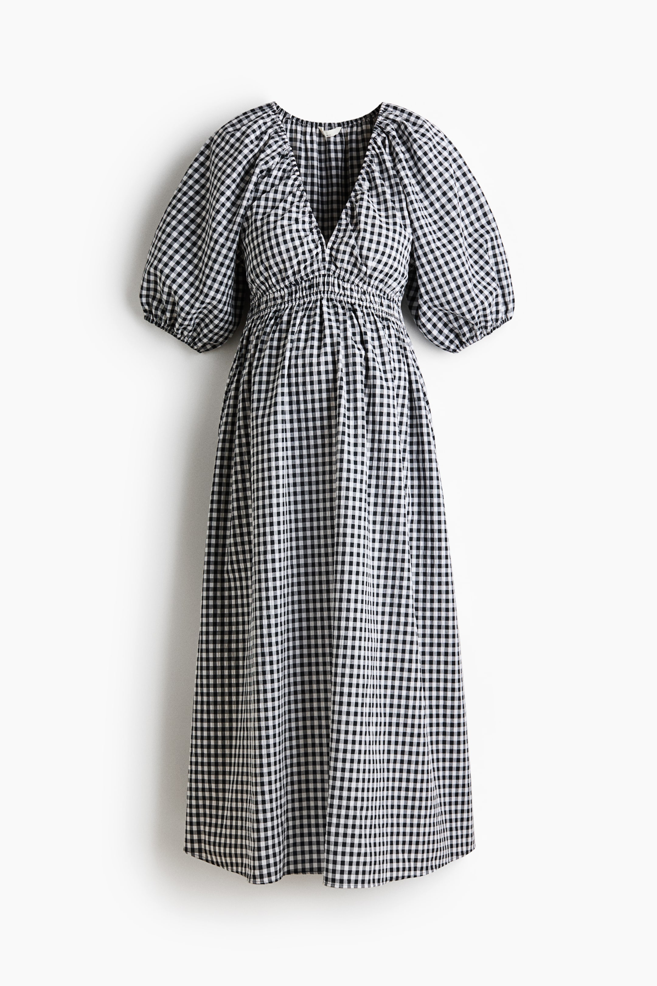 View larger image: The calf-length dress is showcased from the front, highlighting a black and white gingham pattern. It boasts a gathered V-neckline, two rows of narrow elastic bands below the bust, 3/4-length balloon sleeves with elastic cuffs, and a gently flared skirt.