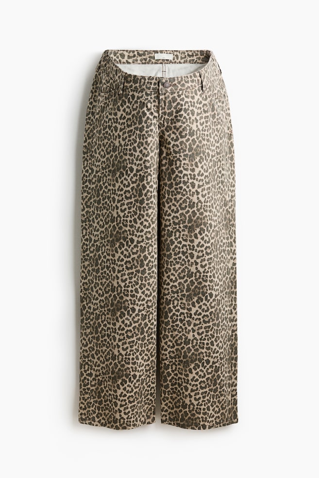 5-pocket jeans are displaying a leopard print pattern, presented flat and facing forward. The jeans are featuring a wide-leg cut from the thigh to the hem, a low waist with belt loops, and a front zip fly and button closure. - 1