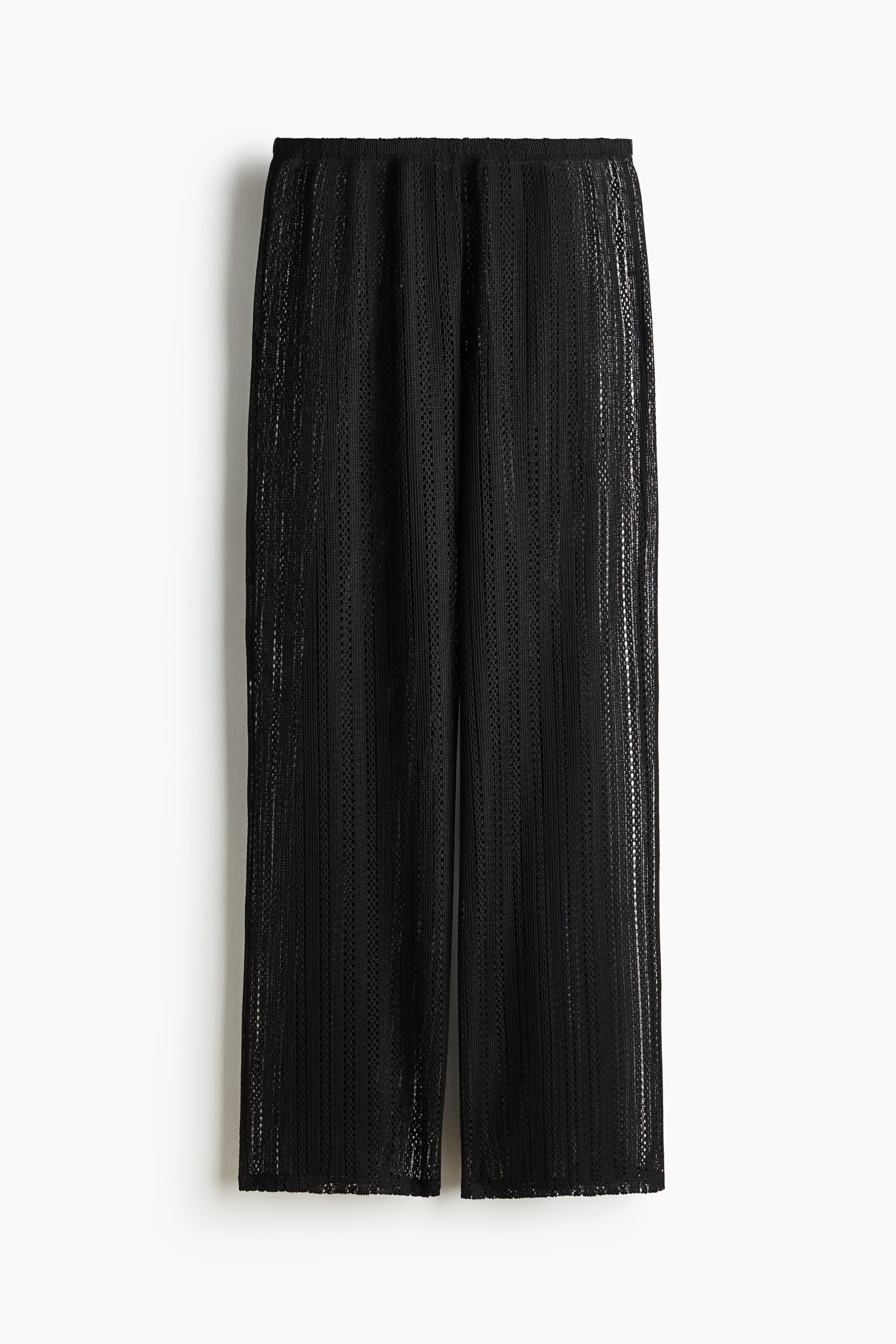 View larger image: "Hole-knit trousers are showcased from the front, with an elasticated waist and wide-leg design."
