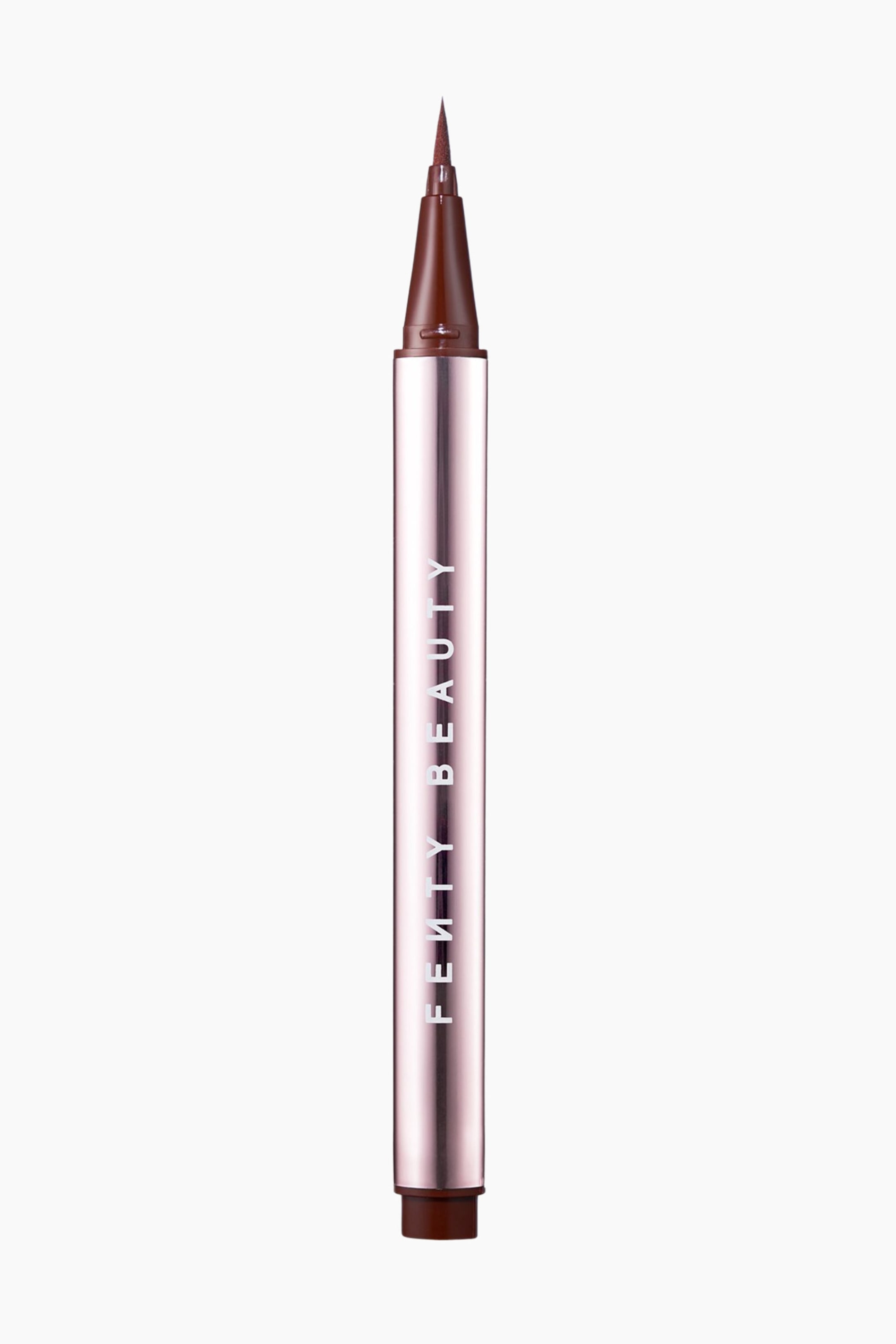Visa större bild: Flyliner Longwear Liquid Eyeliner står upprätt och visar upp en reflekterande, ljusrosa metallisk hylsa med varumärkesnamnet "FENTY BEAUTY" tryckt vertikalt. Den okapade pennan avslöjar en fin, avsmalnande filtspets i mörkbrunt, som matchar den bruna kragen och basen.