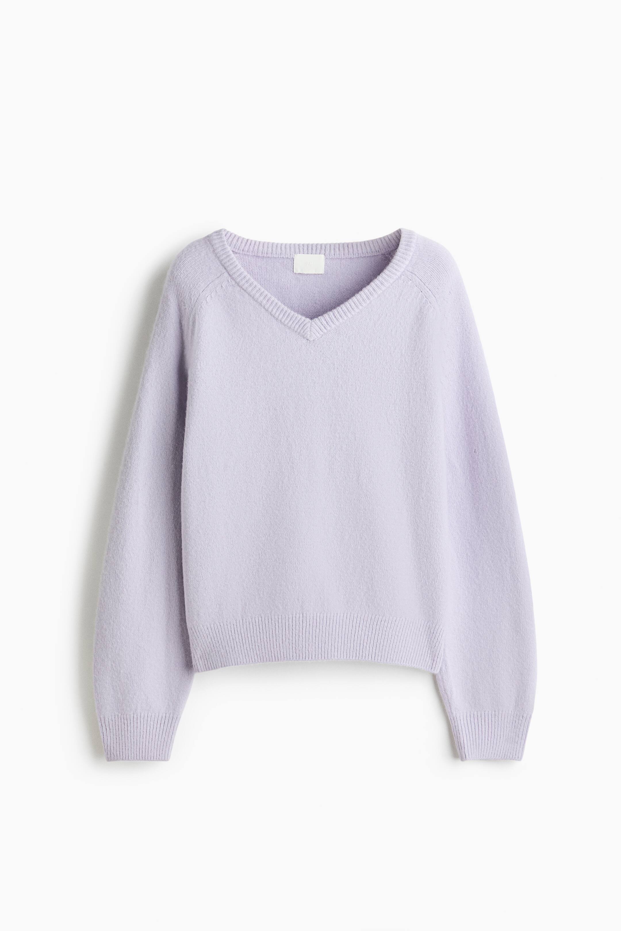 View larger image: A lavender V-neck sweater is being presented from the front, featuring a ribbed V-neckline, raglan sleeves, and ribbed cuffs and hem.