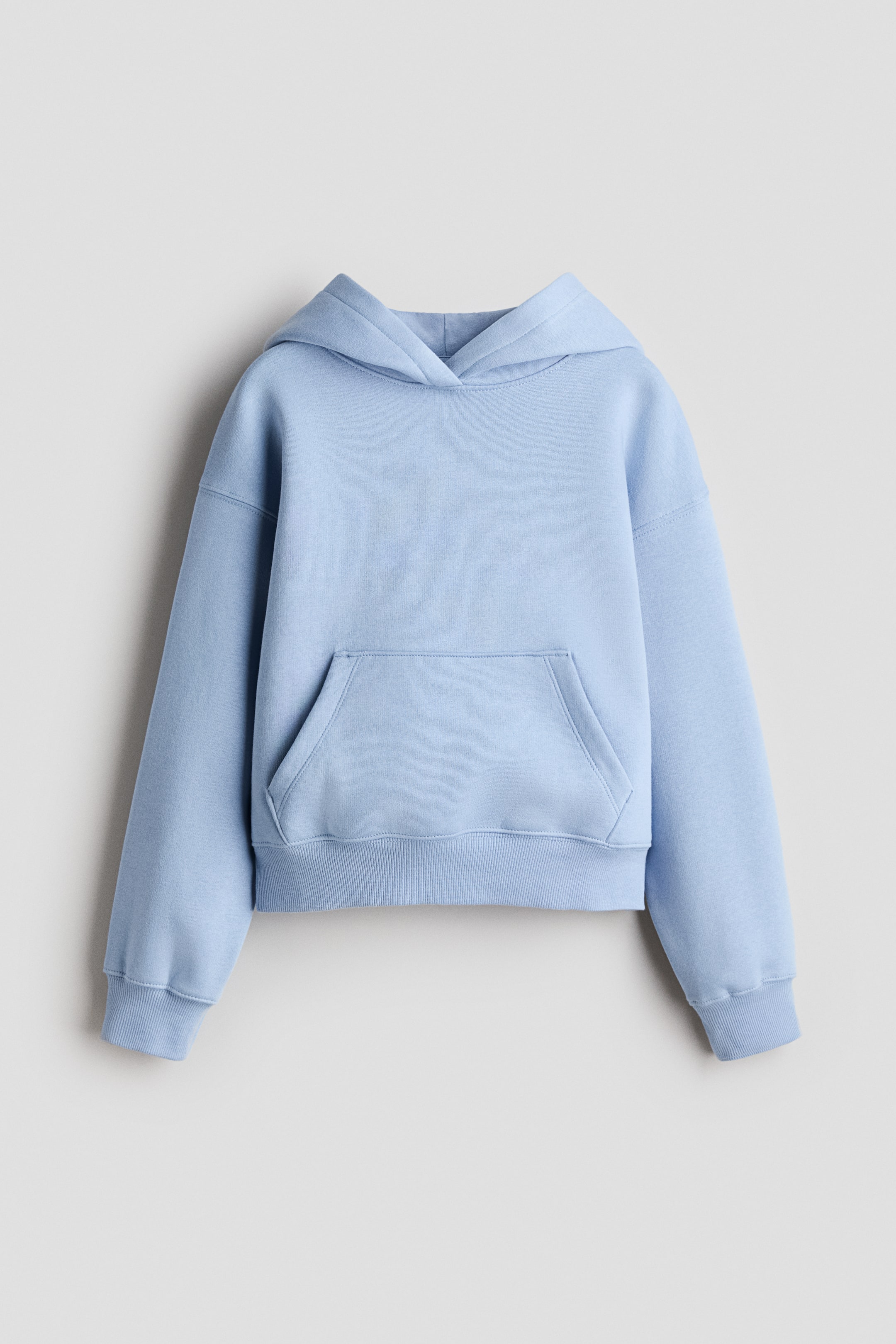 Ver imagen más grande: Una sudadera con capucha corta de color azul claro muestra su vista frontal, con una capucha estructurada, un bolsillo canguro prominente y puños y dobladillo acanalados.