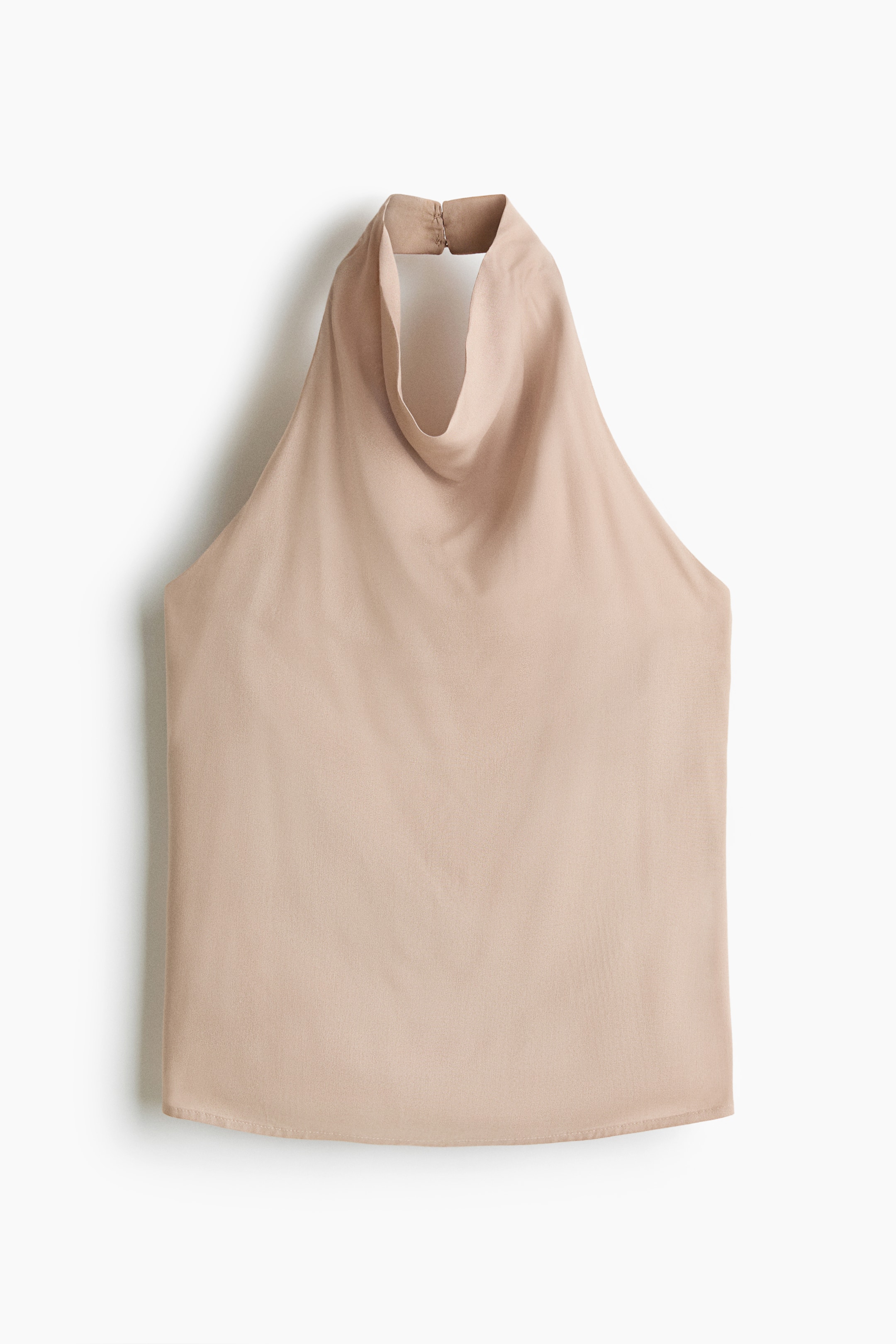 View larger image: A beige halter top is displayed FRONT, featuring a high neckline that fastens at the back of the neck and drapes into a cowl neck. The top is made from a smooth, flowing fabric and has a gently curved bottom hem.