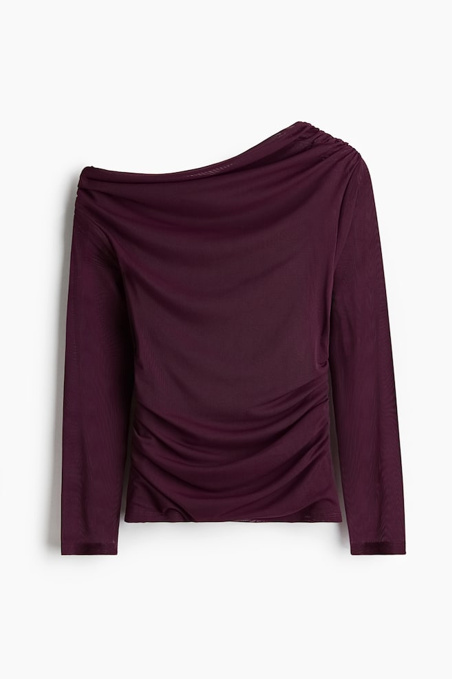 En vinröd topp med en axel är vänd FRAMÅT, med långa ärmar. Toppen har en rynkad design på höger axel och omfattande rynkning längs höger sida och nedre framsidan, och visar upp ett genomskinligt, finstickat tyg. - 1