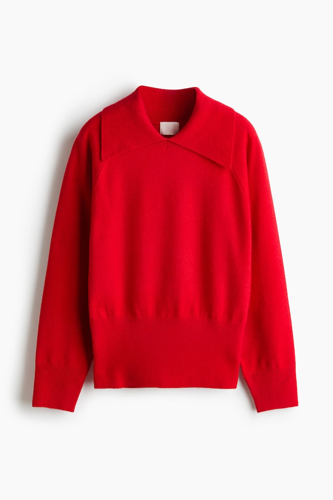A bright red knit sweater is shown from the front, featuring a wide, flat collar and long raglan sleeves. The sweater is designed with a wide ribbed hem and matching ribbed cuffs. - 1