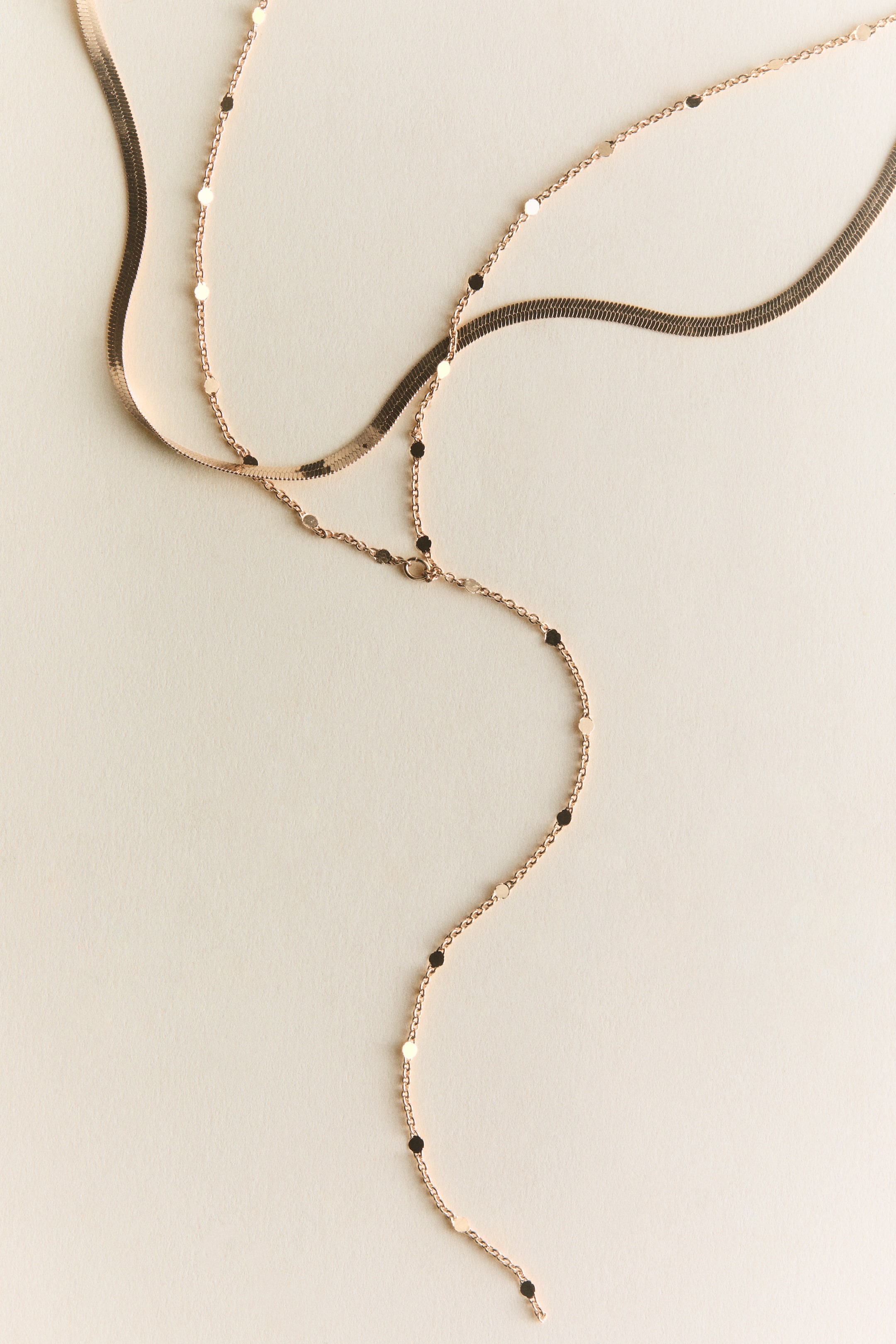 Visualizza immagine più grande: Una collana a strati presenta due catene color oro rosa. Una catena è un serpente piatto e flessibile, mentre l'altra è una delicata catena satellite con piccoli dischi rotondi distanziati lungo la sua lunghezza.