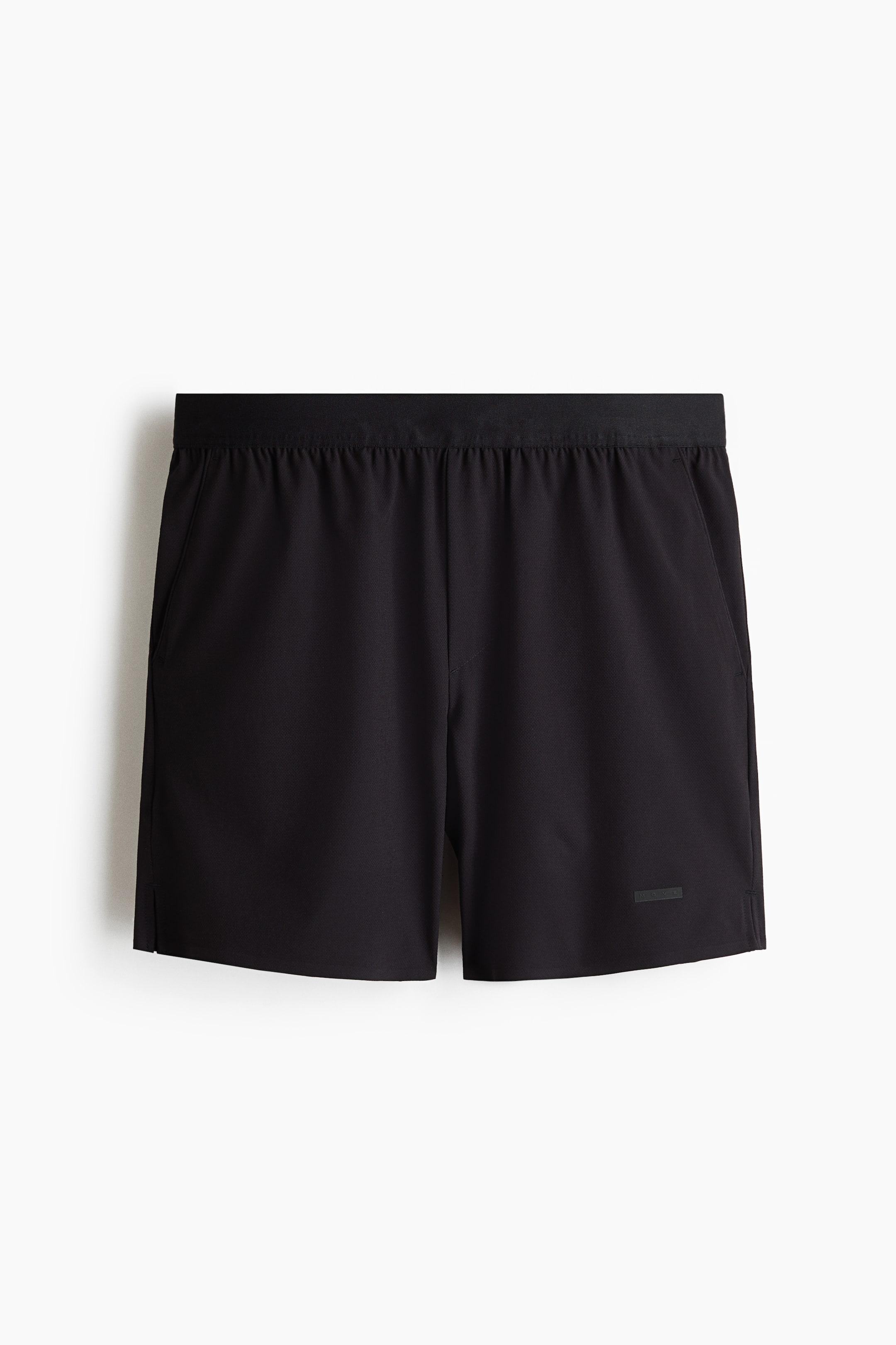 Xem ảnh lớn hơn: Quần short tennis Regular Fit với công nghệ DryMove? được trình bày mặt trước với màu đen. Chúng có đặc điểm là cạp chun với vải gấp nếp, hai túi bên và các khe nhỏ ở viền dưới. Một miếng vá hình chữ nhật màu đen tinh tế có thể thấy ở chân phải phía dưới.