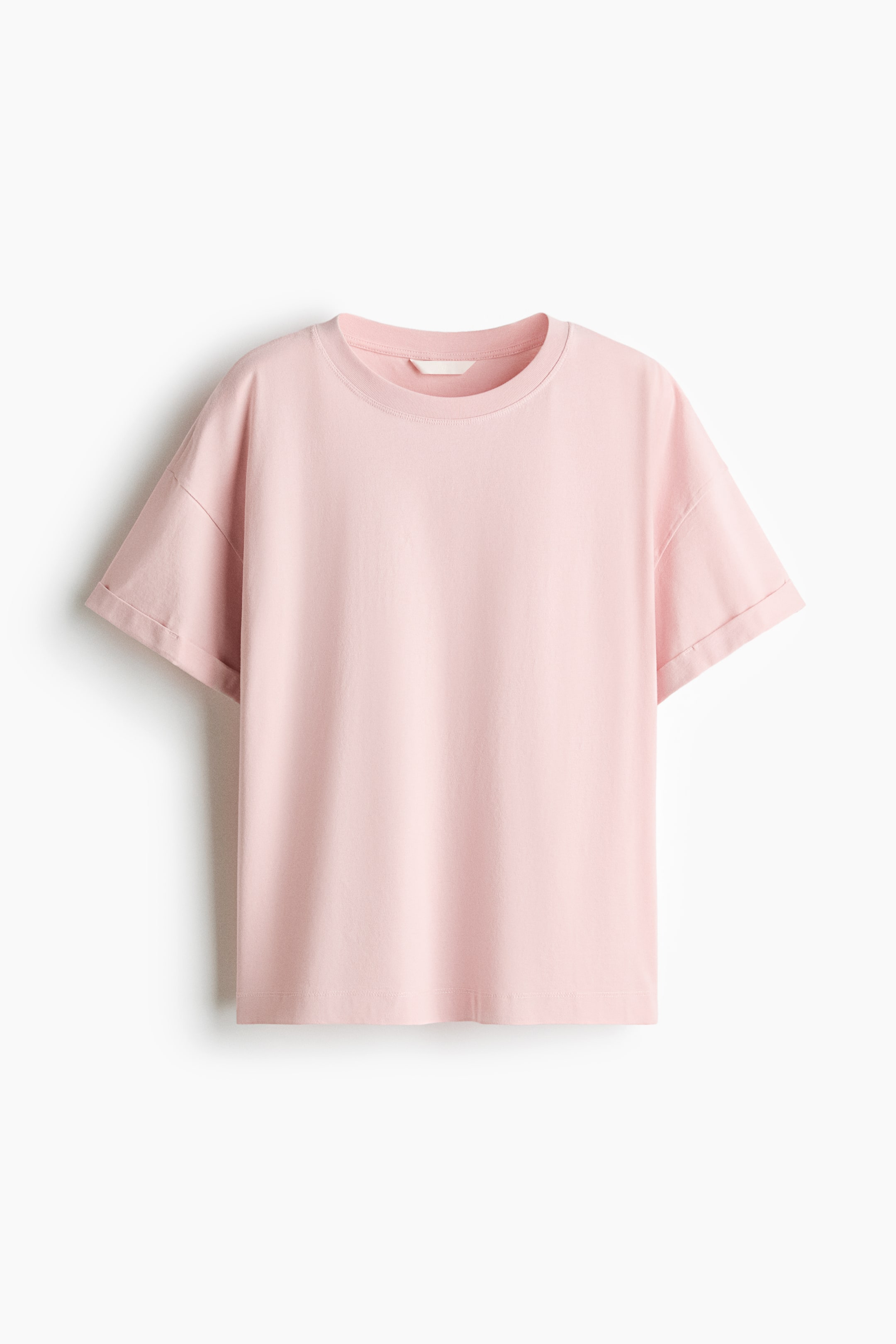 View larger image: A pink T-shirt presents its front, featuring a ribbed round neckline and short sleeves with rolled cuffs.