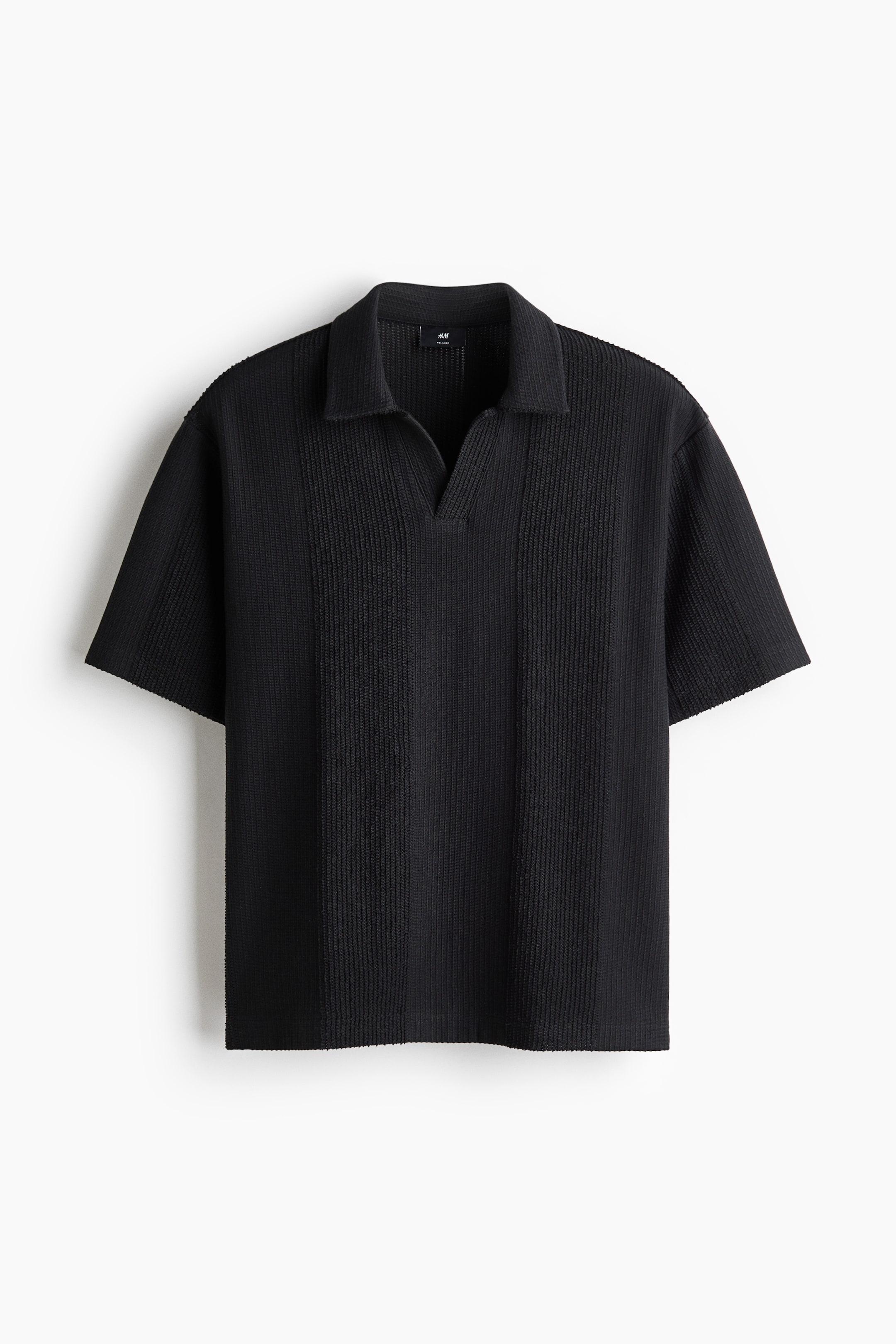 Grösseres Bild ansehen: Ein schwarzes Polohemd mit kurzen Ärmeln zeigt seine Vorderseite, mit einem Polokragen, einem V-Ausschnitt und einer gerippten Strickstruktur mit vertikal breiteren Rippabschnitten.