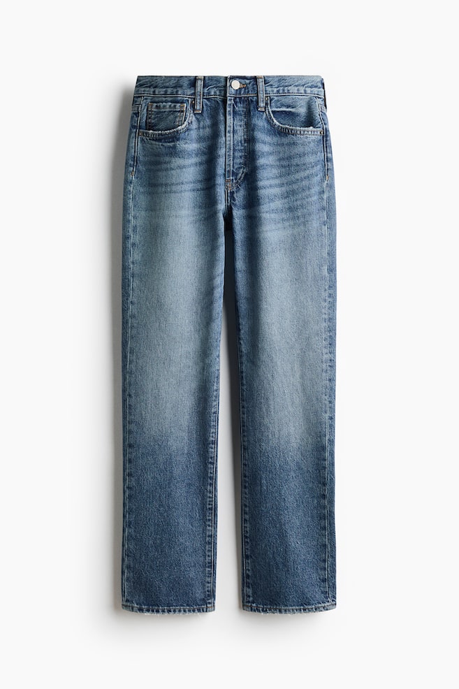A pair of five-pocket jeans in mid-wash blue denim is hanging straight from the front, showing a regular fit and straight-cut legs. The jeans feature subtle fading and whiskering details across the thighs, complete with a button fastening and belt loops at the waistband. - 1