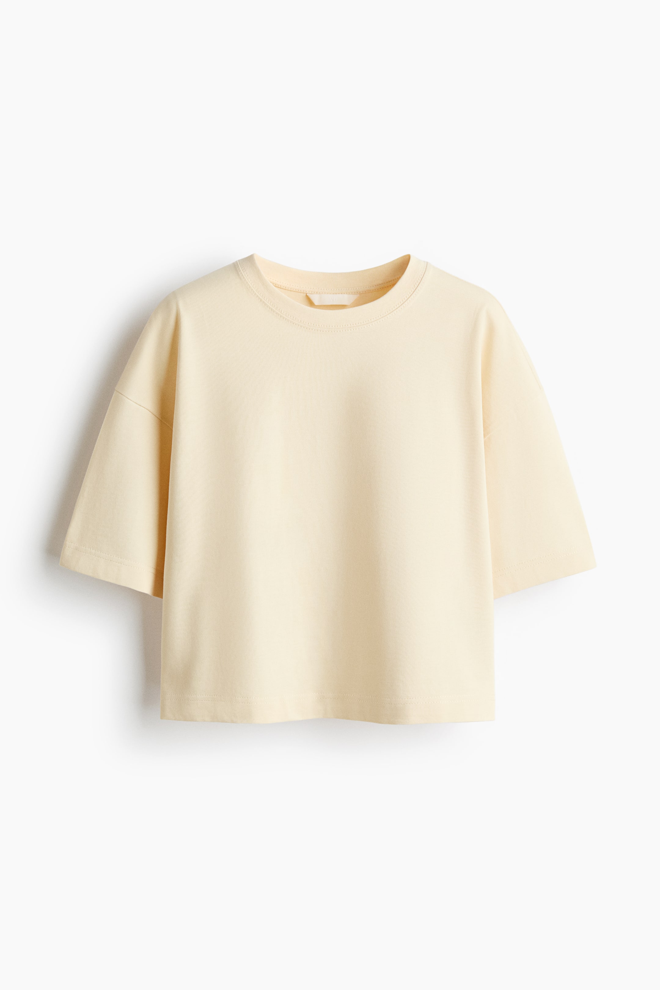 View larger image: A light yellow T-shirt is displayed from the front, showcasing a crew neck and dropped shoulders. It offers a relaxed, boxy fit with elbow-length sleeves and a straight-cut hem.