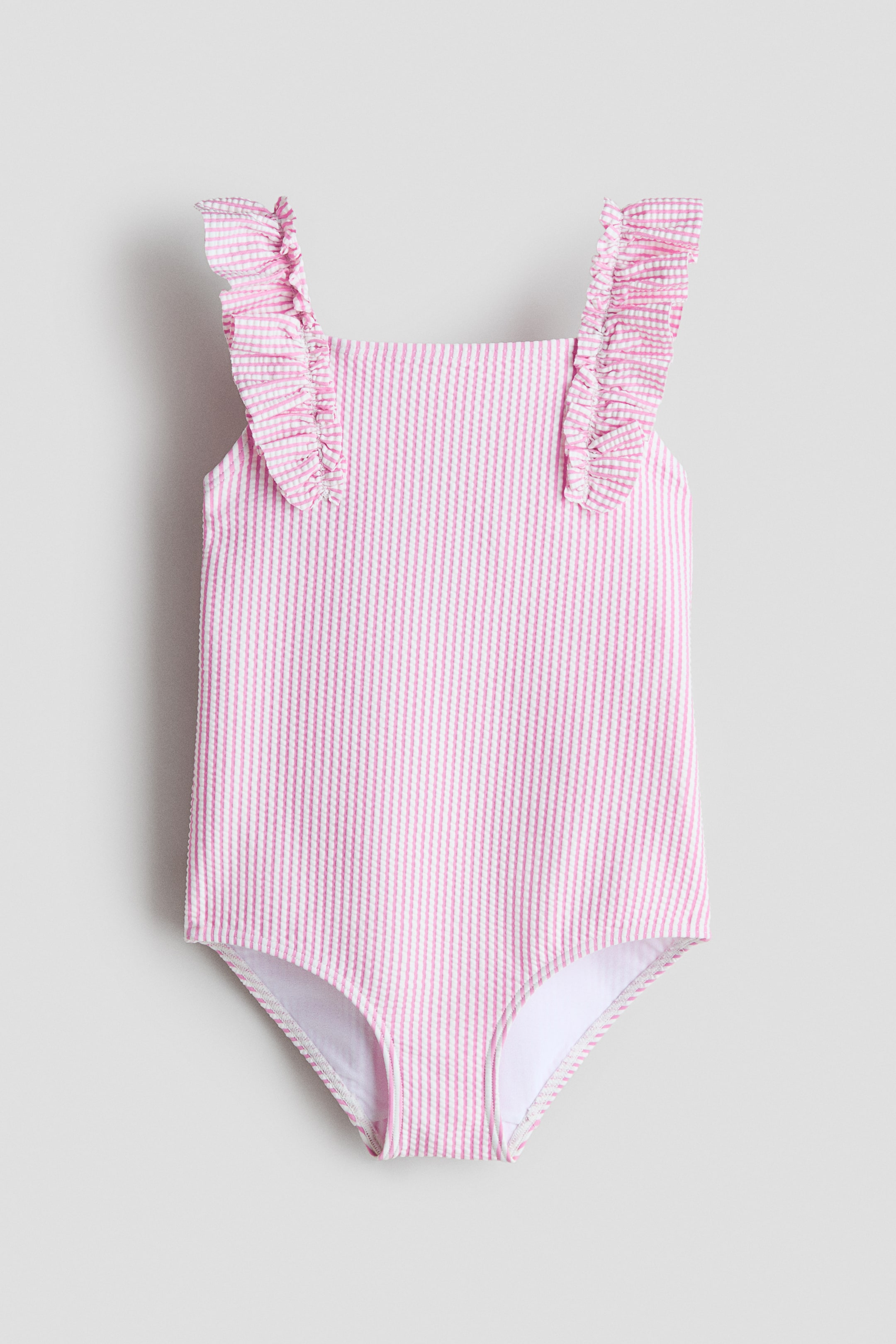 View larger image: The fully lined, textured swimsuit is showcased in the FRONT view, featuring a pink and white vertical striped pattern, a square neckline, and elasticated, frill-trimmed shoulder straps.