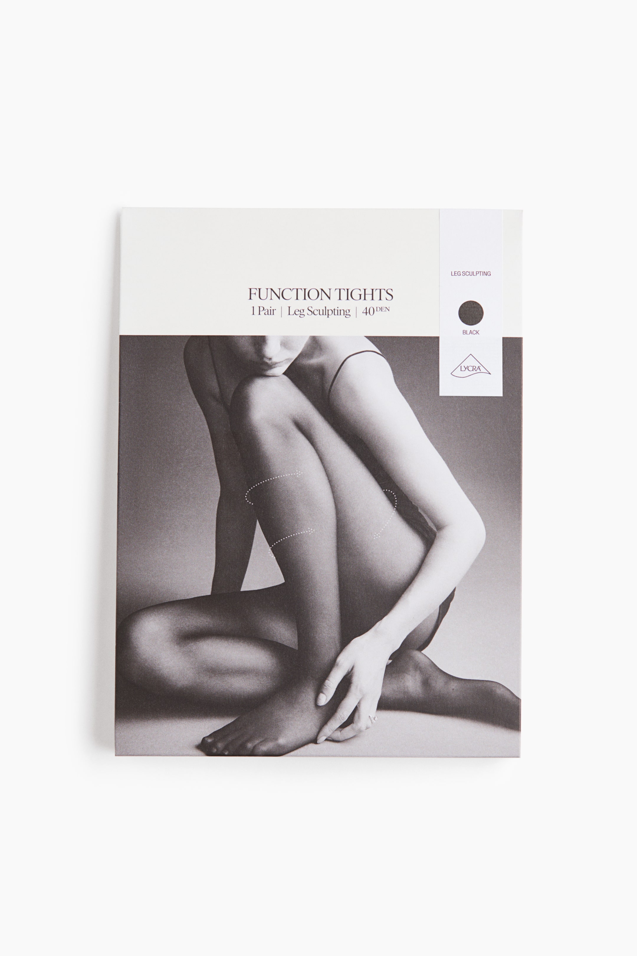 Zobacz większy obraz: Opakowanie Function Tights stoi pionowo, prezentując białą górną część z napisem „FUNCTION TIGHTS | 1 Pair | Leg Sculpting | 40 DEN”. Pionowy biały pasek po prawej stronie zawiera napis „LEG SCULPTING”, czarne kółko oznaczające kolor oraz logo „LYCRA”. Dolna część przedstawia czarno-białe zdjęcie nóg i tułowia osoby, z kropkowanymi liniami podkreślającymi wybrane obszary na nogach.