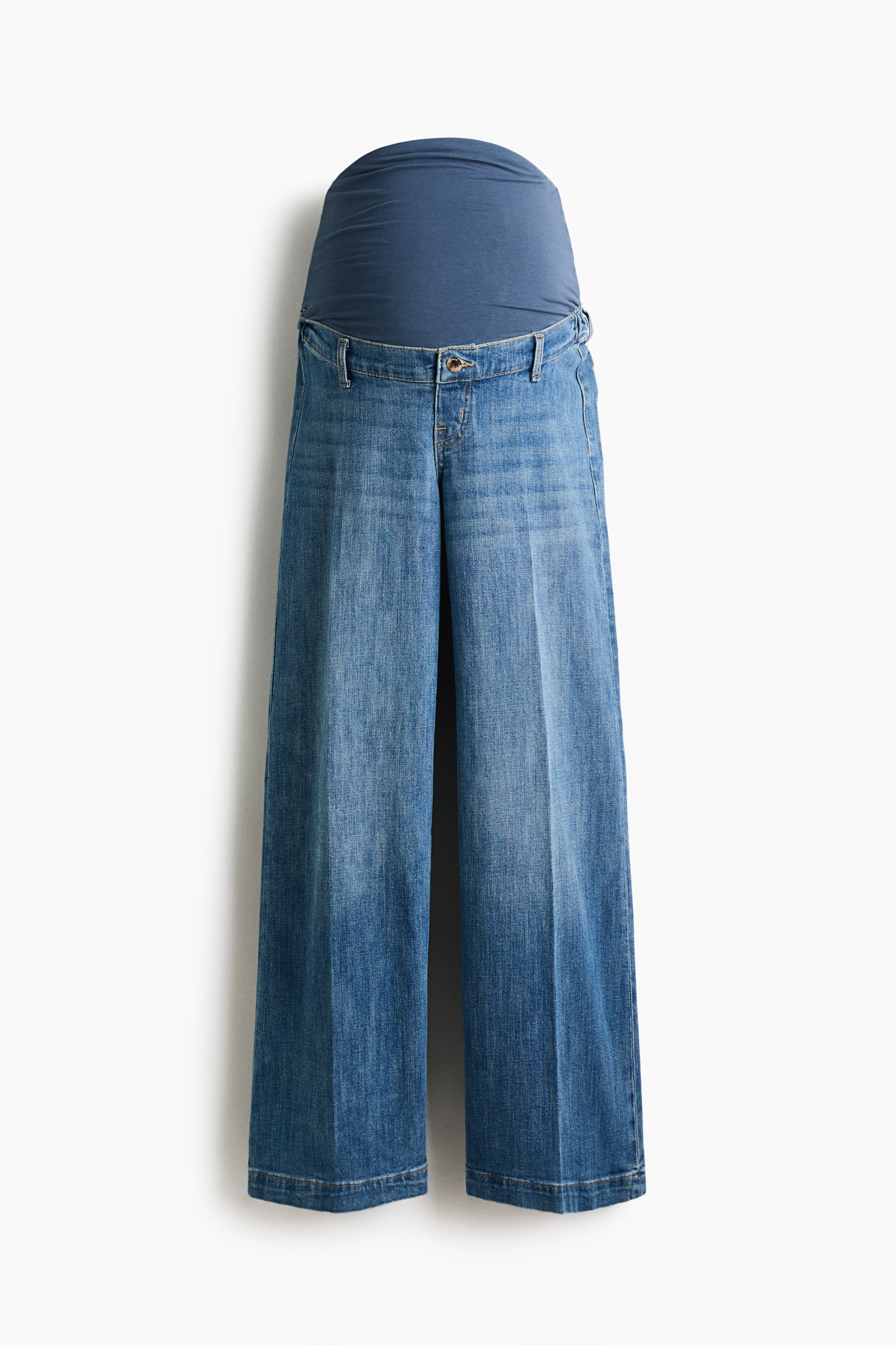 View larger image: A pair of blue cotton denim jeans featuring a high-rise waist and wide-leg cut, with pressed creases running down the front of the legs. A wide, dark blue jersey panel extends upward from the denim waistband, and a zip fly with button closure is visible at the front.
