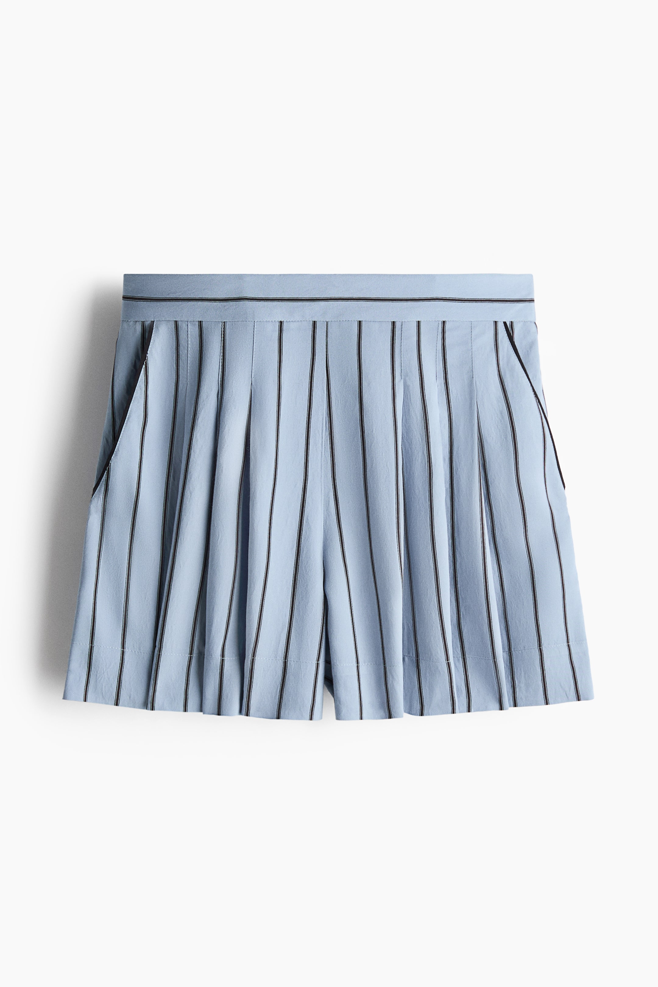 View larger image: Light blue pleated shorts showcase a frontal view, highlighted by vertical black stripes. They boast slanted side pockets accented with black trim and a waistband adorned with two slender black stripes.