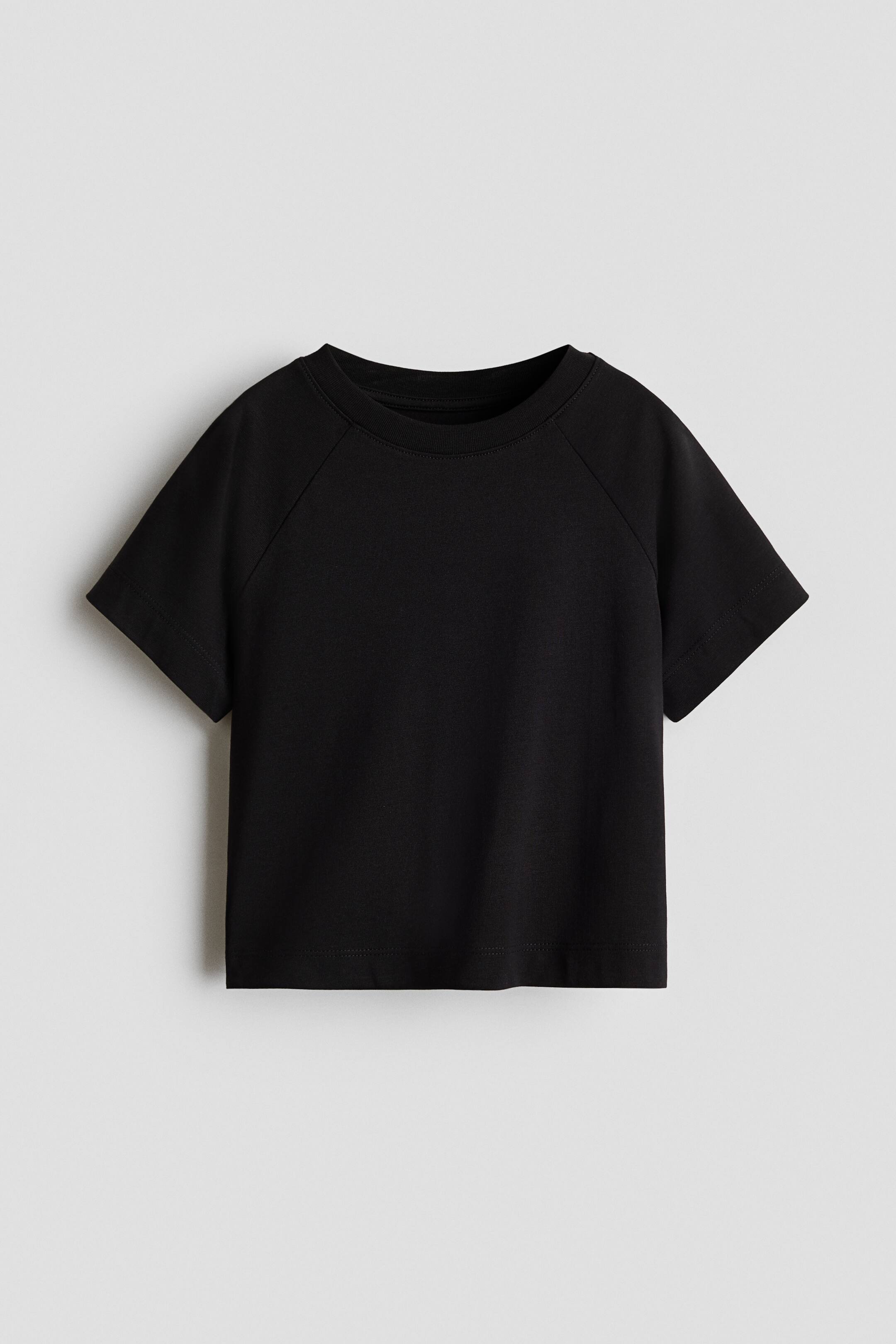 查看大圖: 一件黑色短袖 T 恤正面展示,採用羅紋圓領及 raglan 袖設計。這件 T 恤呈現略短身、方正剪裁,袖口及下擺均有乾淨俐落的車縫收邊。