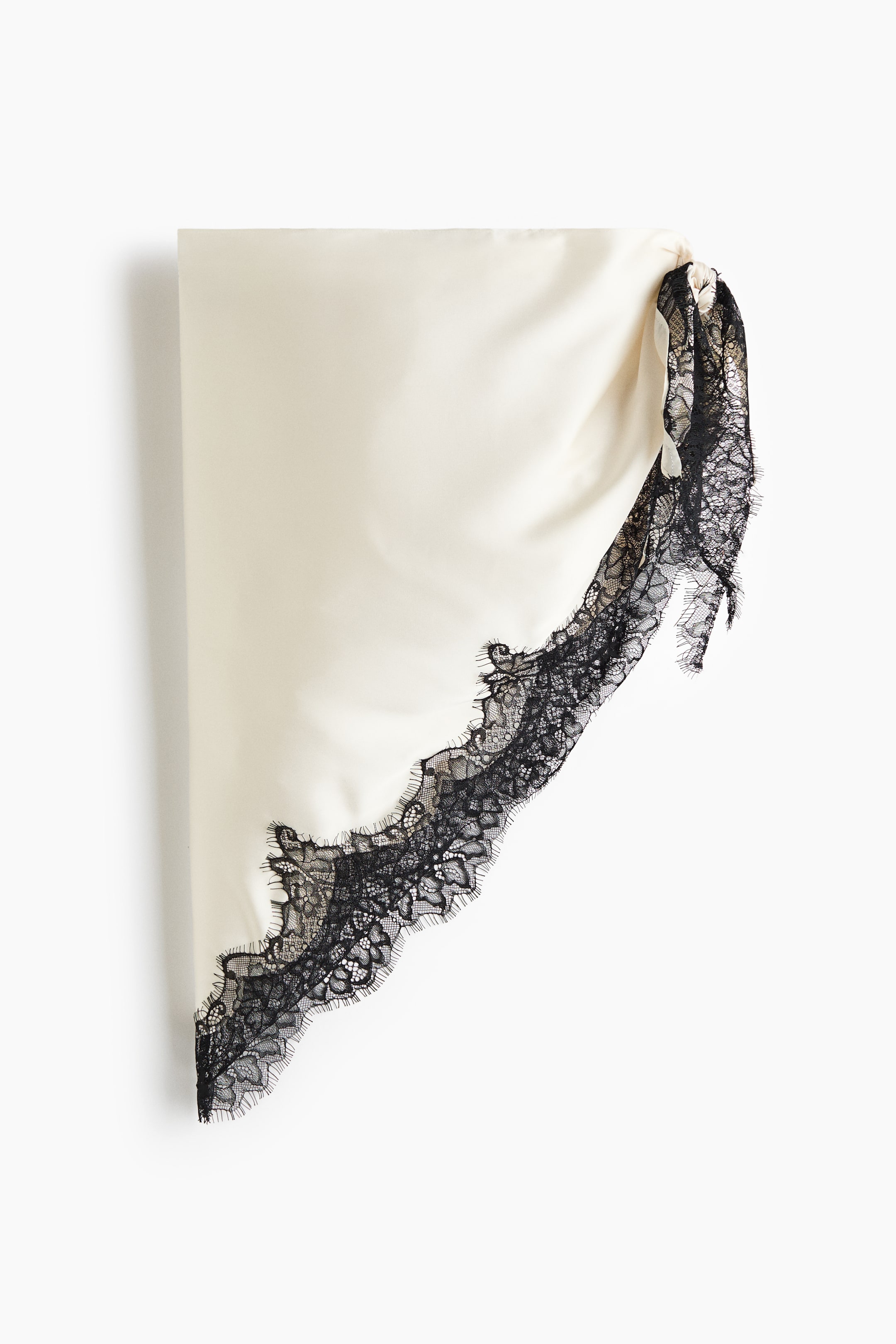 View larger image: "A large triangular scarf showcasing elegantly draping cream satin, completed with black lace trim along two sides."