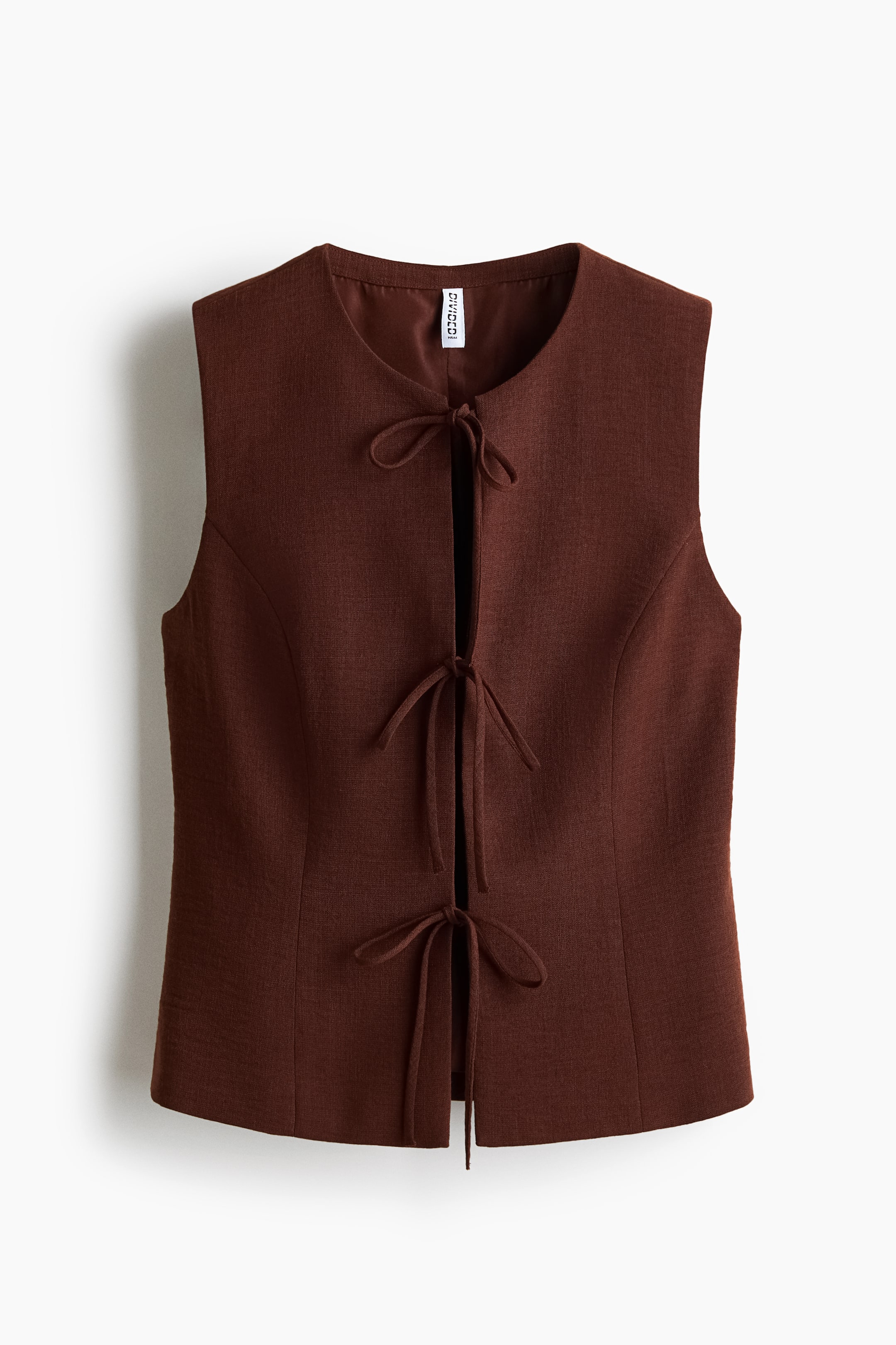 View larger image: A dark brown sleeveless vest is displayed from the FRONT, showcasing a round neck, a subtly textured fabric, and an open front fastened by three visible tie closures forming bows.