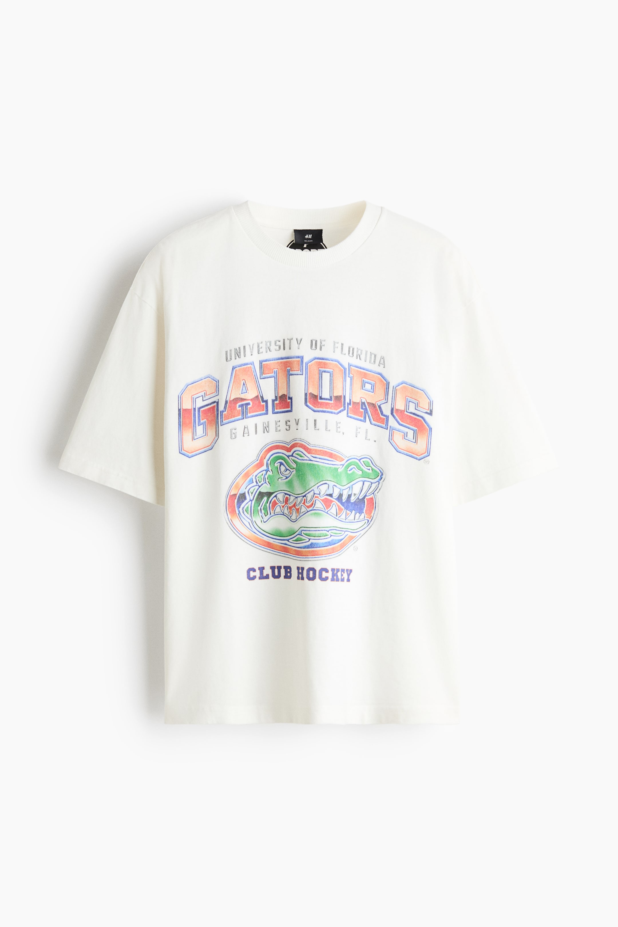 View larger image: A cream-coloured crew neck T-shirt is shown from the front, featuring a relaxed fit and short sleeves. The front displays a distressed collegiate graphic with the text "UNIVERSITY OF FLORIDA GATORS" arched over a green alligator logo and "CLUB HOCKEY" printed underneath.