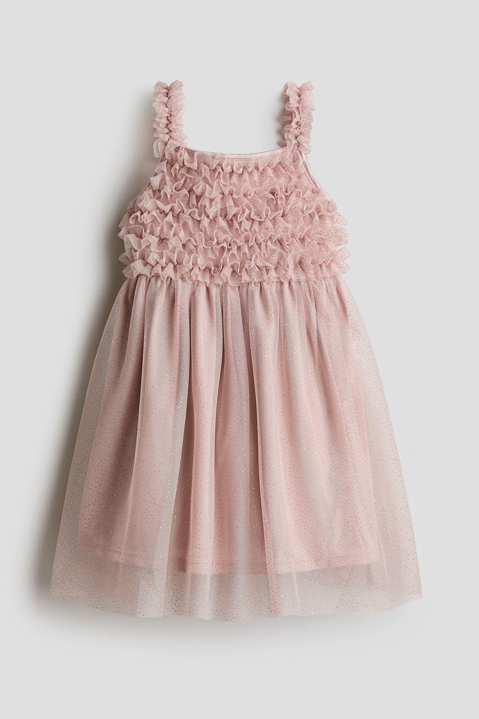 Ein hellrosa Kinderkleid ist frontal ausgerichtet und zeigt ein Oberteil, das mit dichten, horizontalen RÃ¼schenreihen bedeckt ist, sowie dazu passende gerÃ¼schte TrÃ¤ger. Das Kleid fÃ¤llt in einen A-Linien-Rock, der Ã¼ber einer soliden rosa Unterlage mit einer transparenten TÃ¼ll-Ãberlage mit Glitzerpunkten versehen ist.