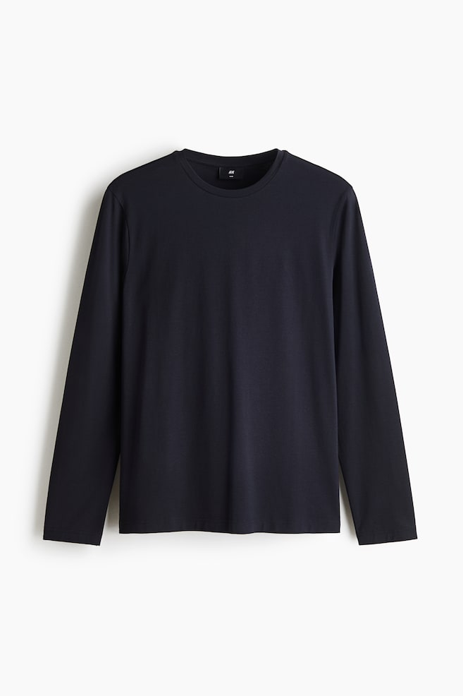 Ein dunkel marineblaues Langarm-T-Shirt ist von vorne zu sehen und verfügt über einen klassischen Rundhalsausschnitt sowie eine lockere Passform. Das Kleidungsstück zeigt eine glatte, einfarbige Struktur mit geradem Saum und schlicht vernähten Bündchen. - 1