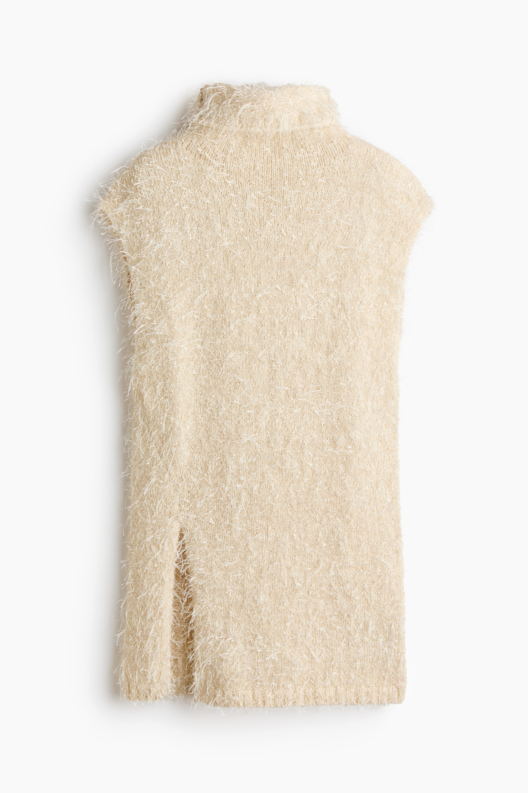 Se større billede: Et lysebeige ærmeløst højhalset plagg viser en pjusket strikket tekstur med længere fibre. Det har en lige søm, der inkluderer en enkelt sideslids.
