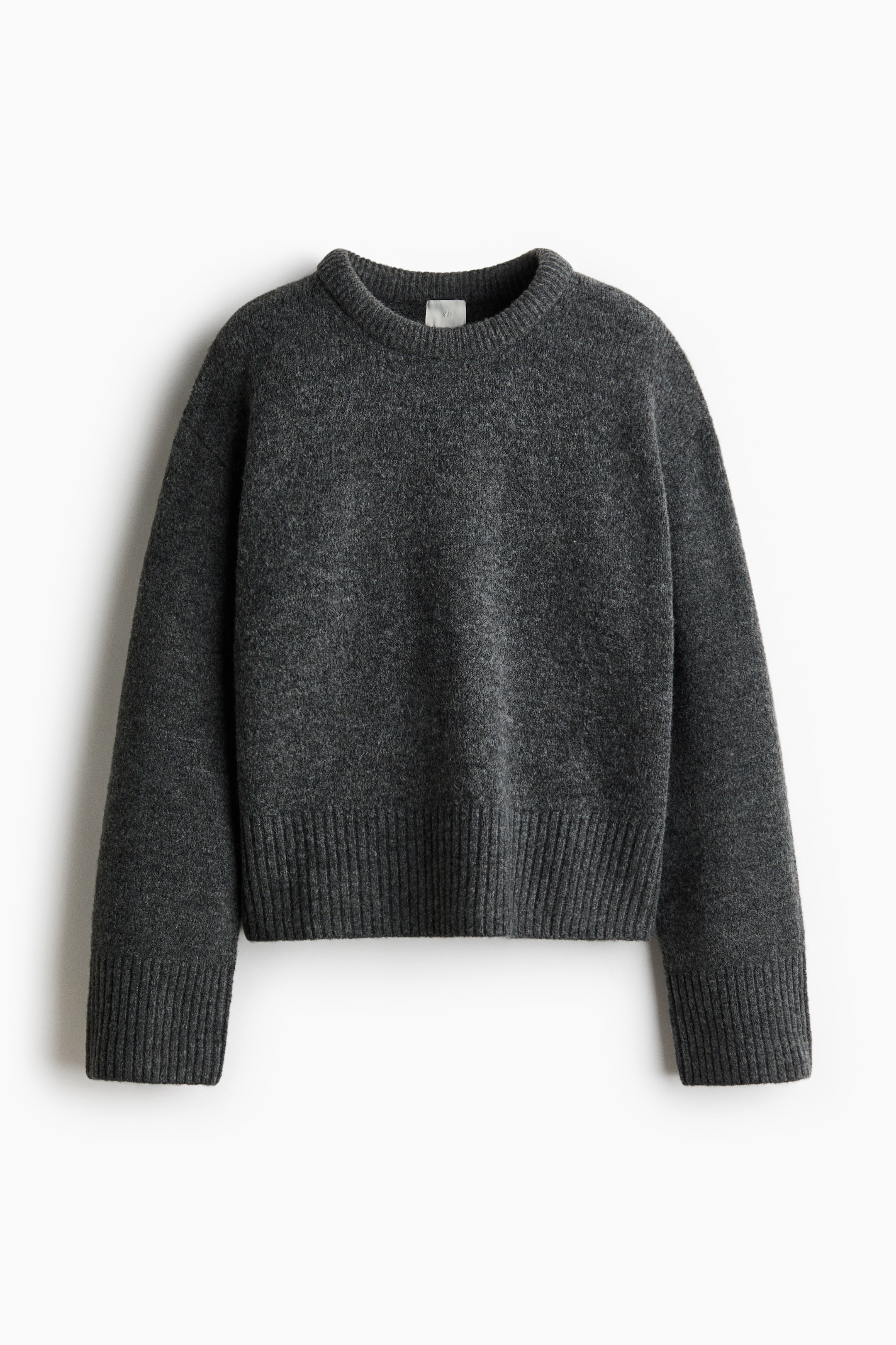 Ver imagen más grande: Un jersey de color gris oscuro se muestra desde el frente, con cuello redondo, una textura ligeramente suave y puños y dobladillo de canalé ancho.