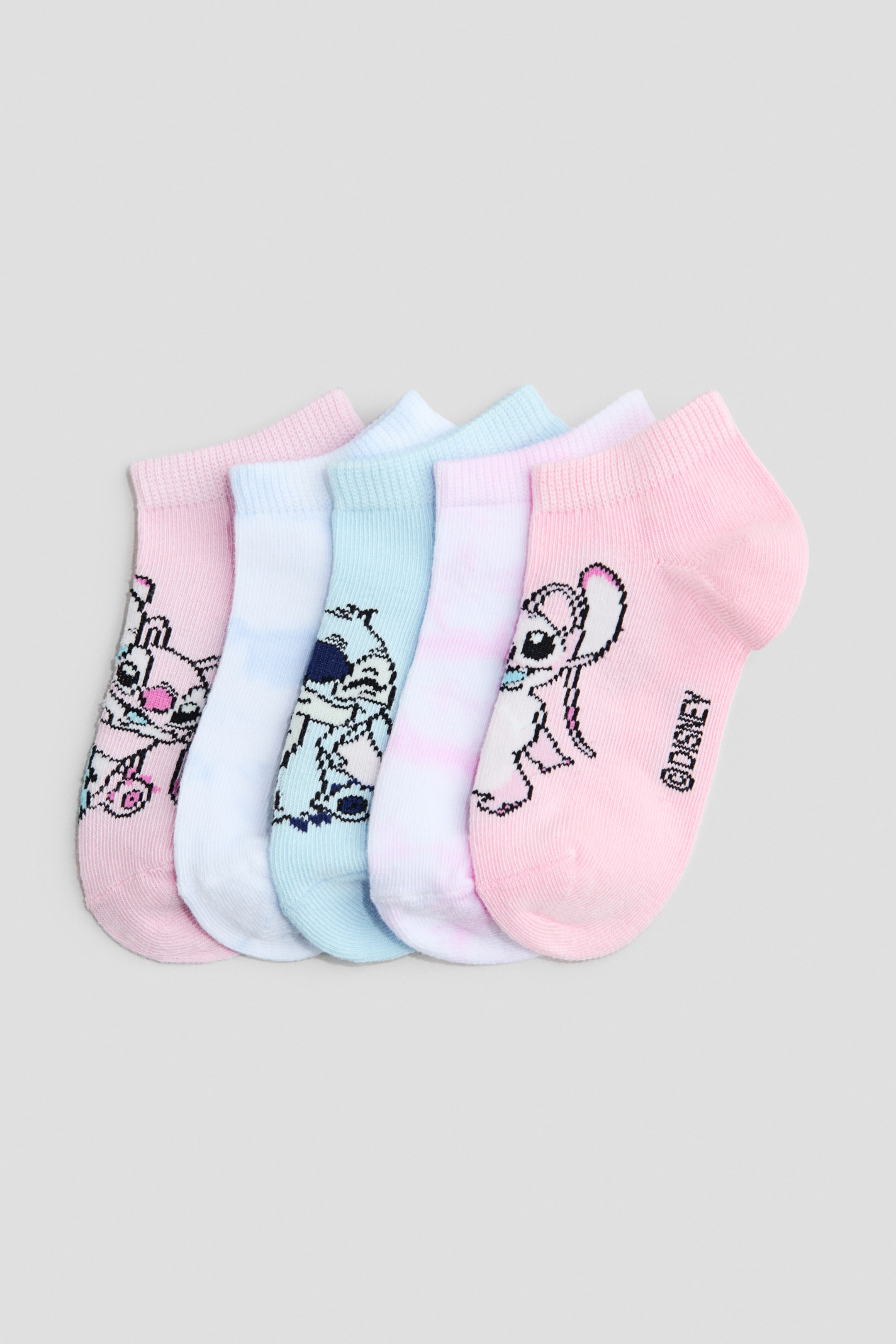 Voir une image plus grande: Cinq chaussettes sans tige, fabriquées à partir d'un mélange de coton finement tricoté avec des hauts côtelés élastiqués, sont disposées en éventail, présentant leurs côtés avant. Elles sont colorées dans des nuances de rose, bleu clair et blanc, et chaque chaussette affiche un imprimé de personnage de dessin animé.